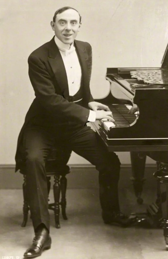 Foto antiga do músico britânico Harry Fragson, sorrindo em um retrato.