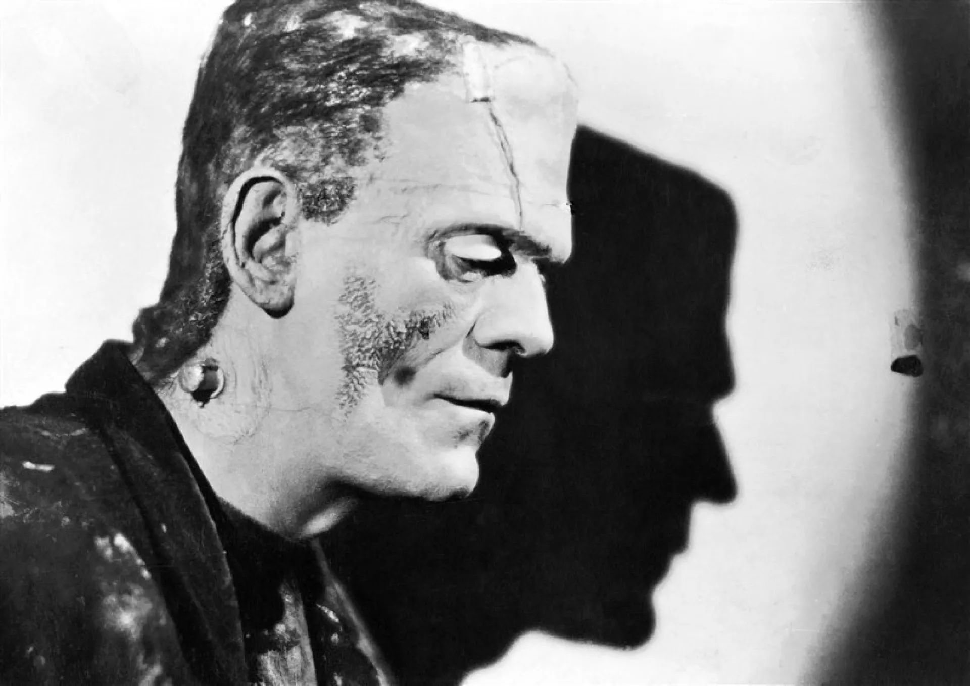 Uma mão saindo da terra, em uma cena que remete a histórias de terror como Frankenstein.