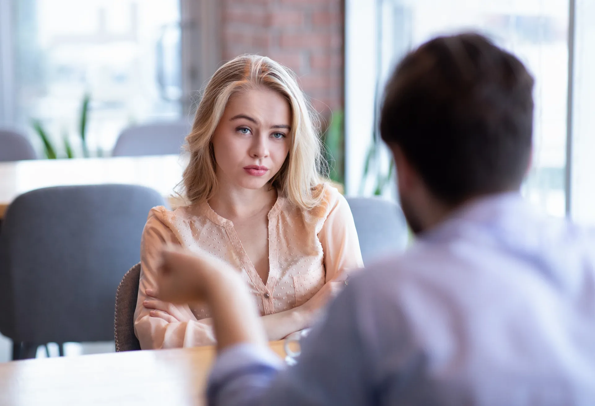 Pessoa com uma expressão neutra diante de outras com emoções fortes, como alegria e tristeza, simbolizando a falta de reconhecimento emocional.