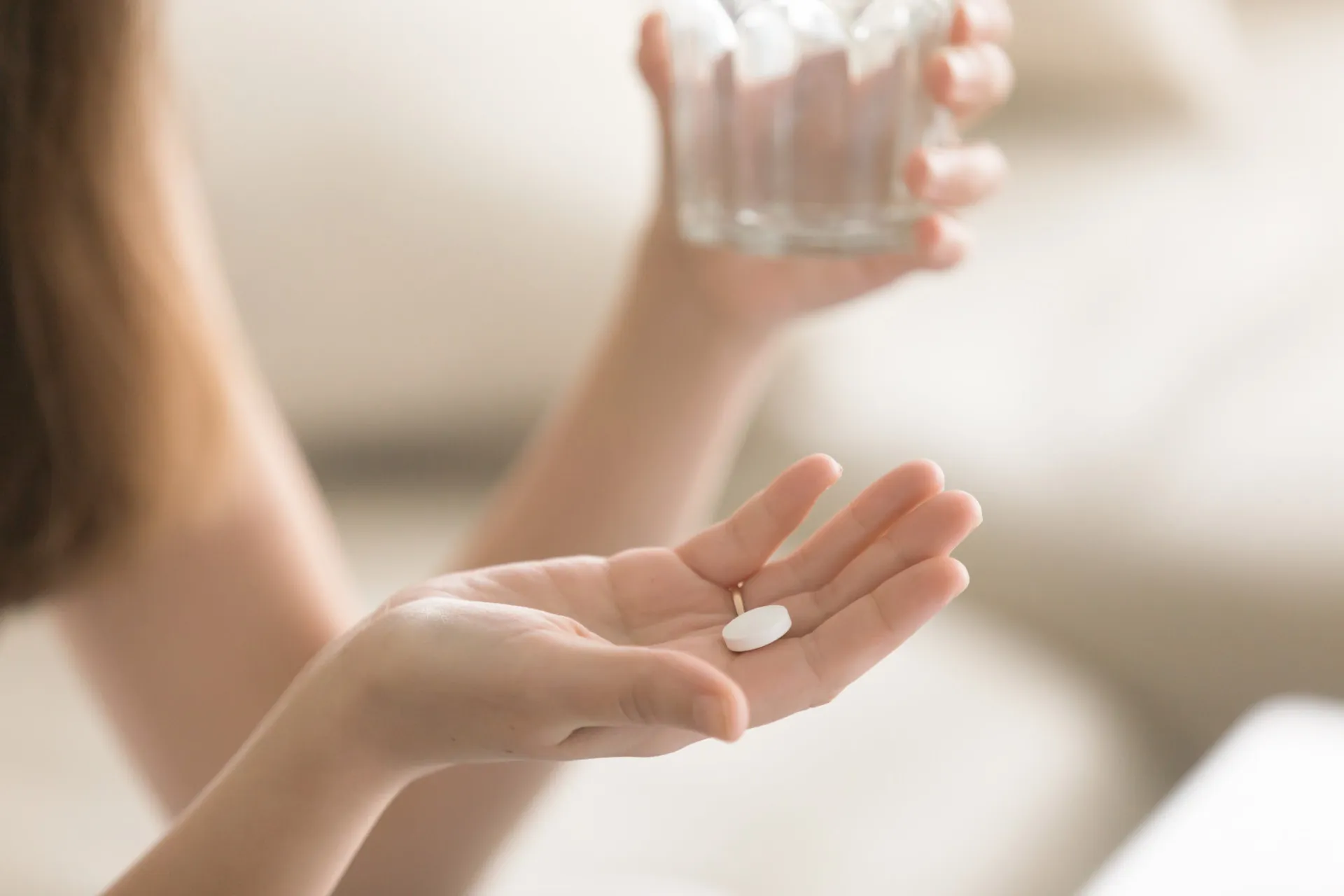 Vários medicamentos em pílulas e cápsulas ao lado de uma prancheta médica com anotações.