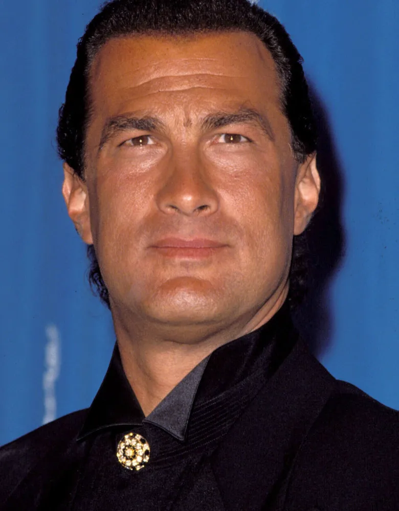 Steven Seagal com uma expressão séria, em um evento público.