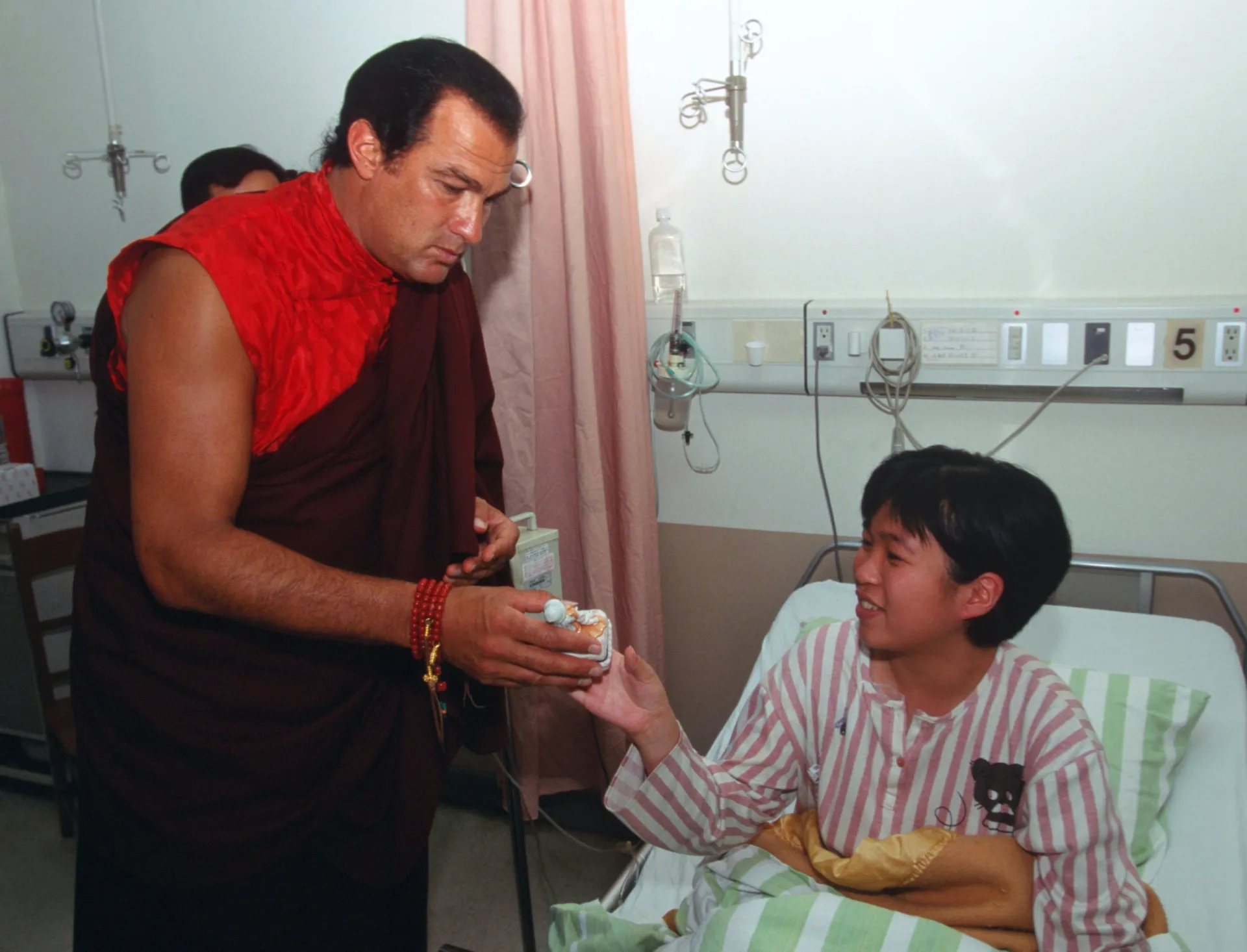 Steven Seagal em um momento de carinho com jovens em um hospital em Taipei, Taiwan.