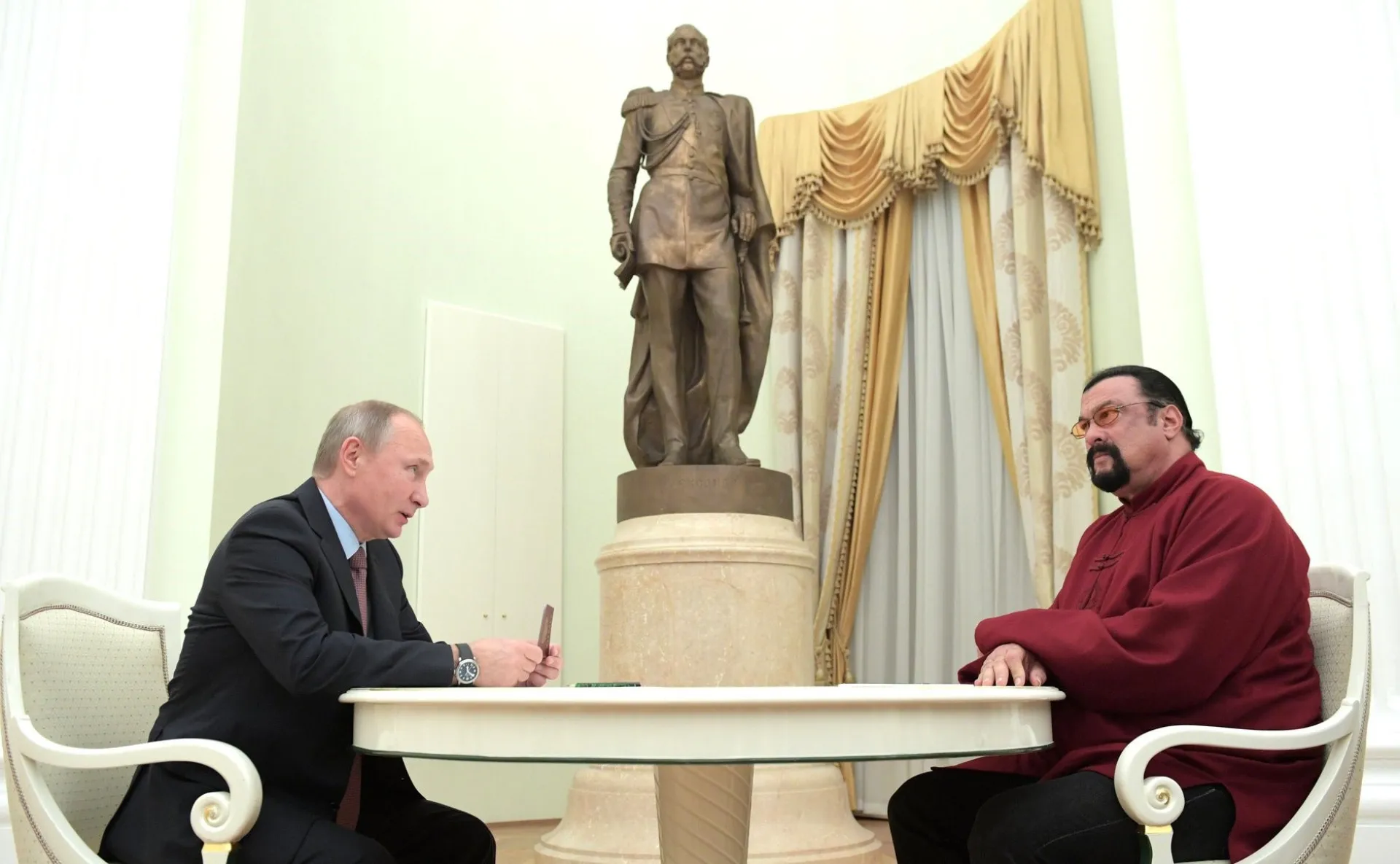 Vladimir Putin entregando um passaporte russo a Steven Seagal em cerimônia oficial.