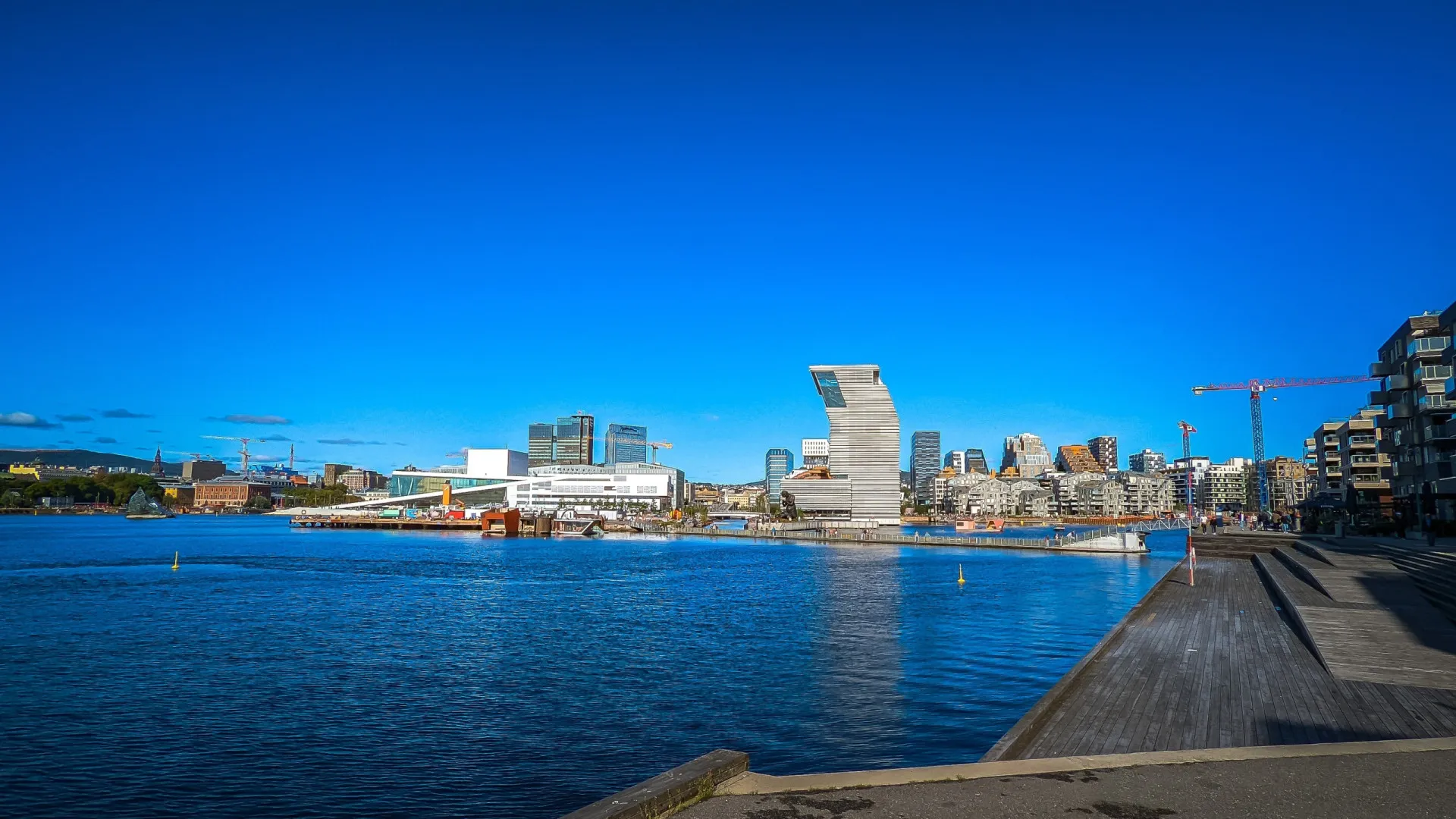 Vista do porto e da cidade de Oslo, na Noruega, com barcos e edifícios modernos.