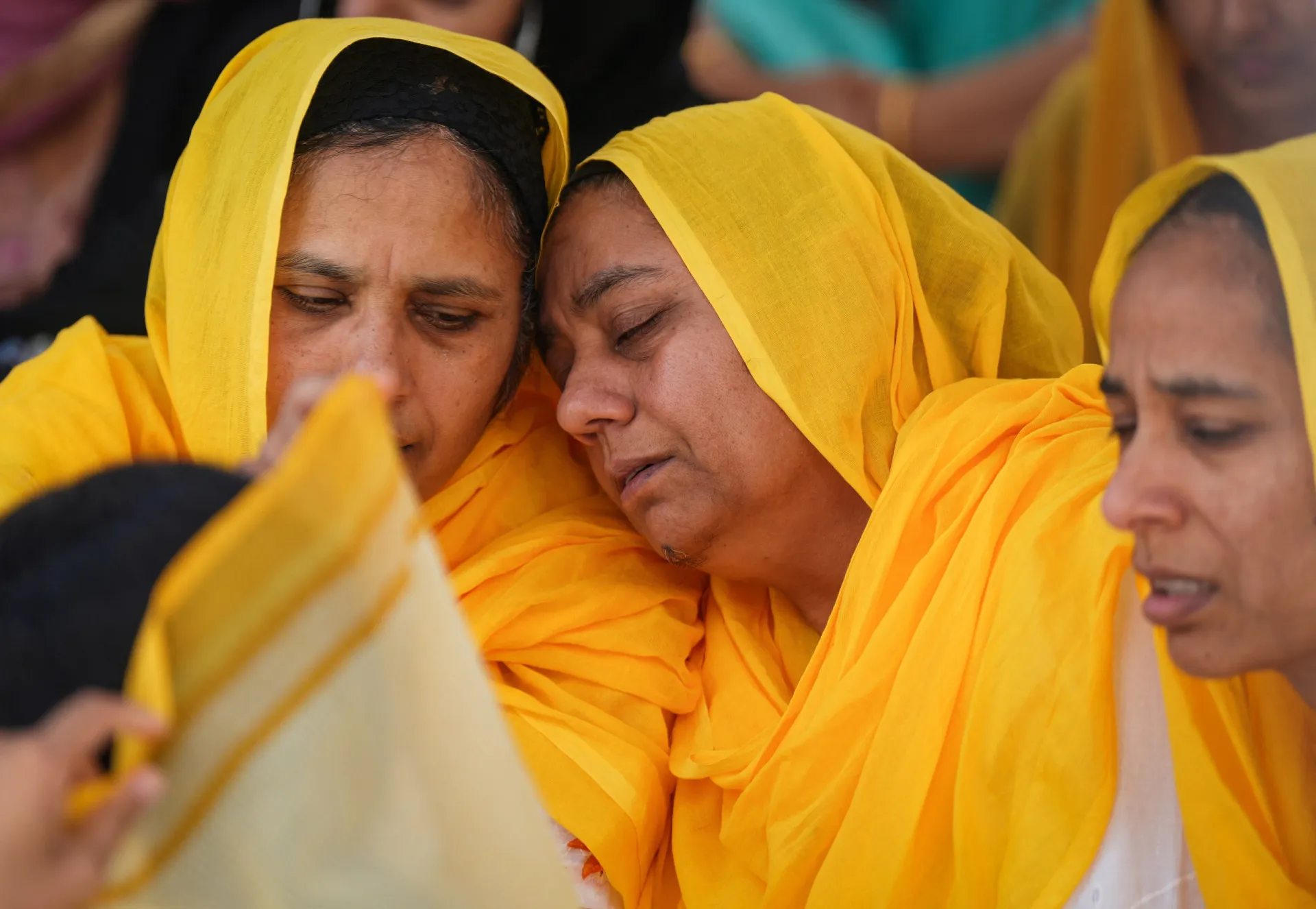 Pessoas chorando e se abraçando durante o funeral de Hardeep Singh Nijjar.