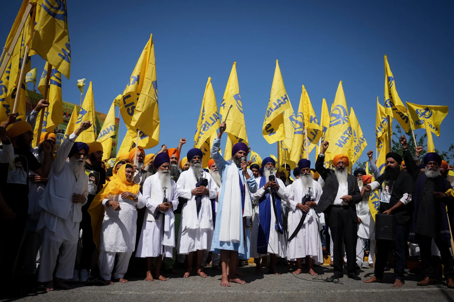 Manifestantes agitando bandeiras amarelas do Khalistan durante o funeral.