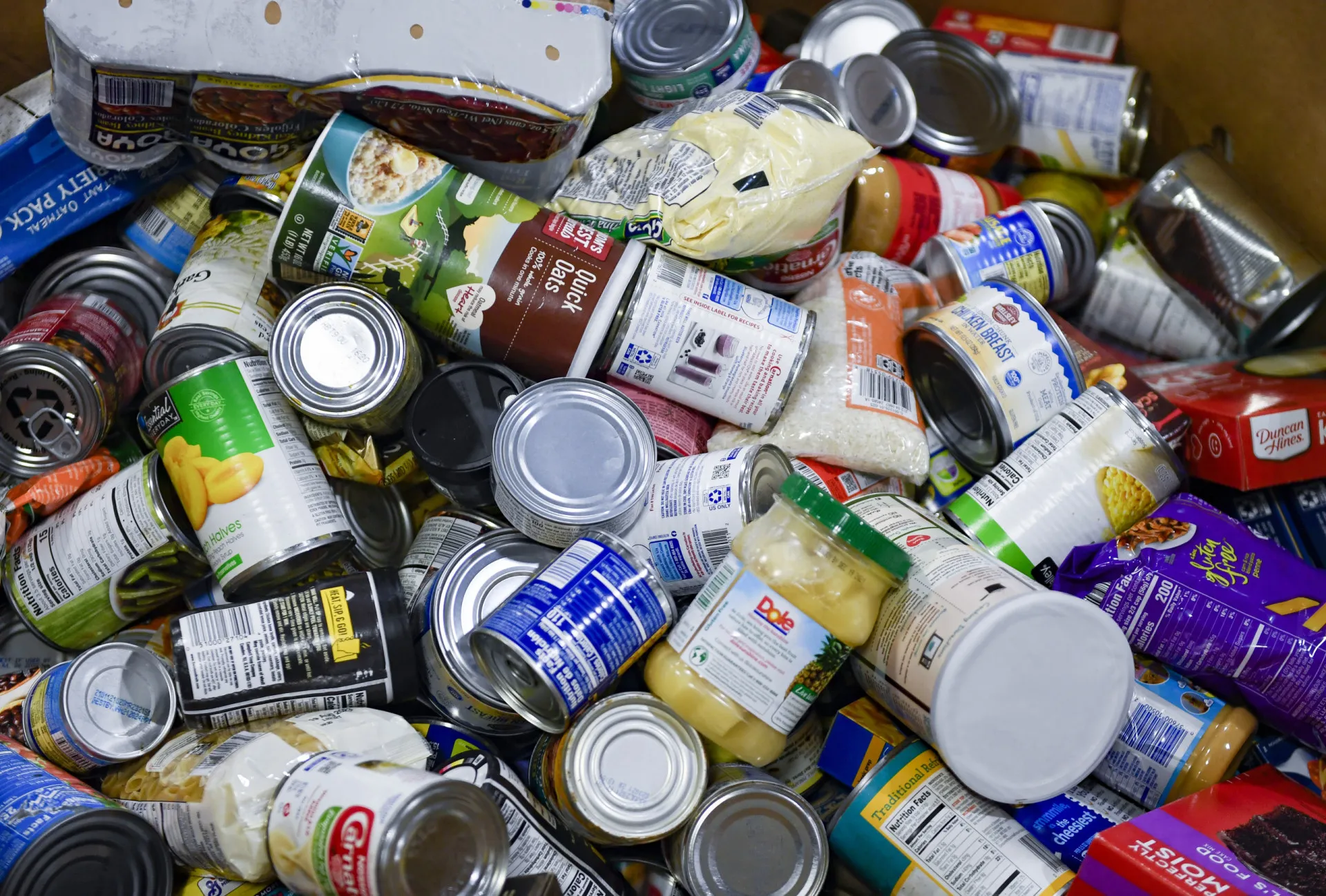 Voluntário organizando alimentos doados em um banco de alimentos.