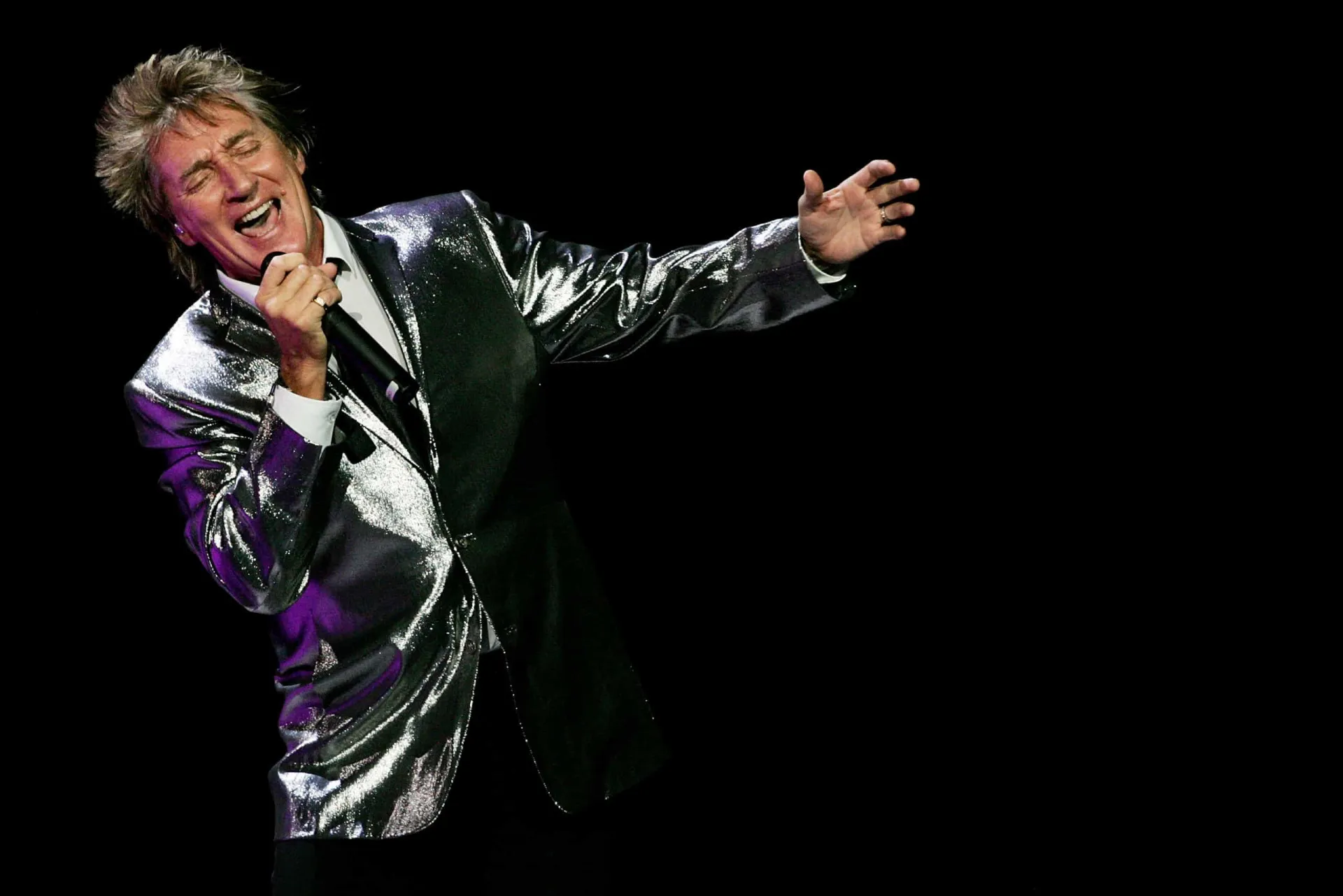 Rod Stewart sorrindo em uma foto mais recente, refletindo sobre sua vida.