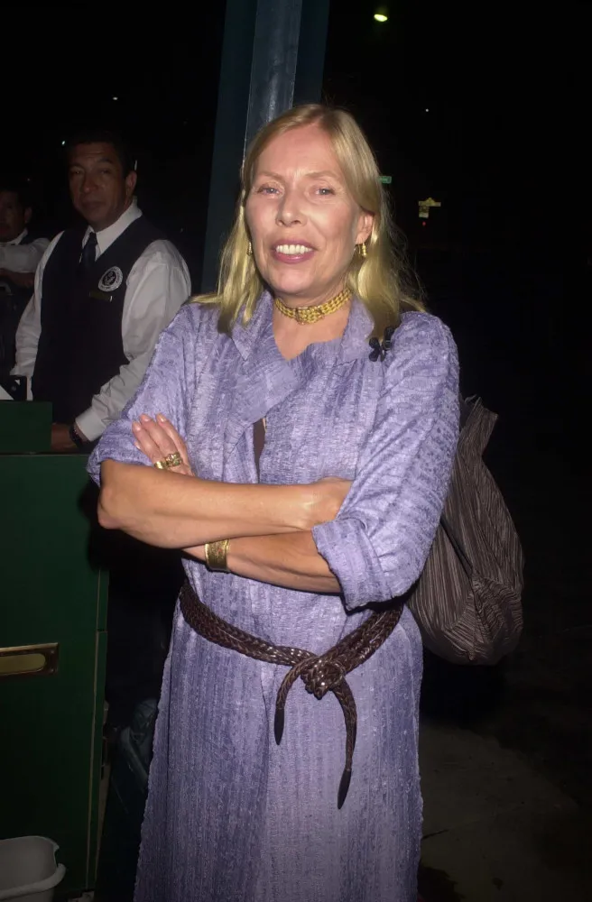 Joni Mitchell sorrindo em um evento, anos depois de sua revelação.