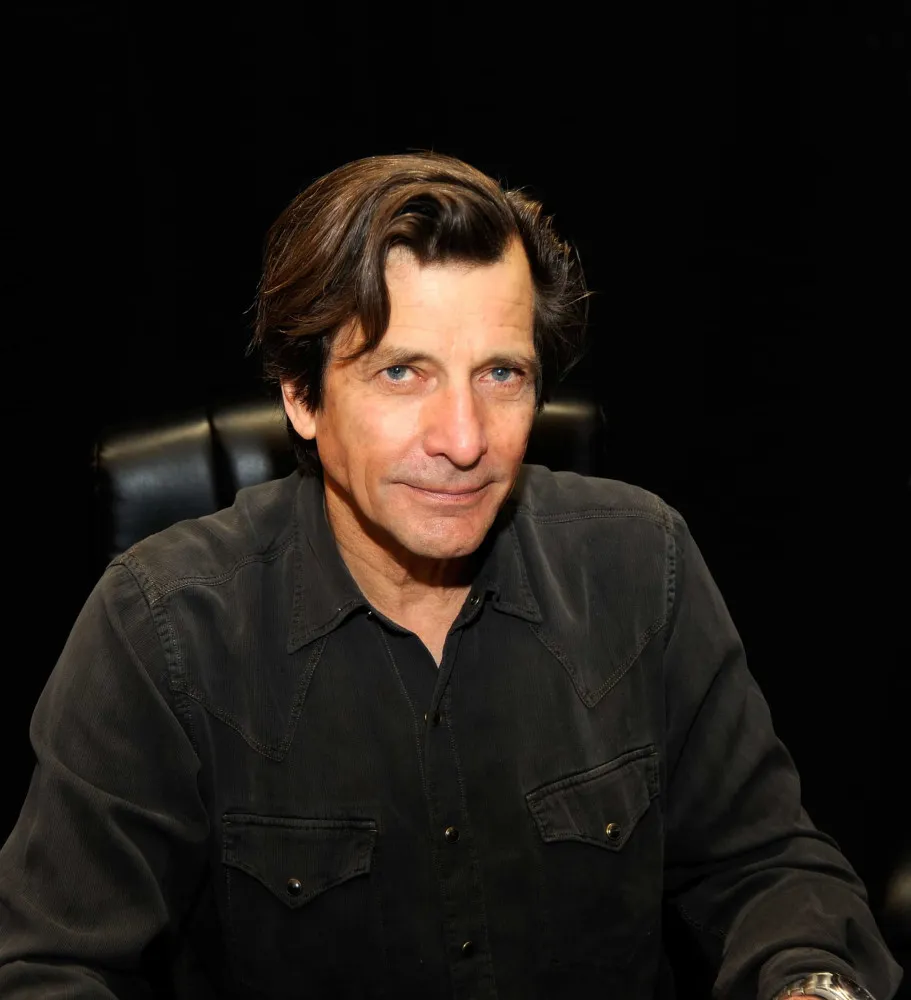 Dirk Benedict com um olhar sério em um evento público.