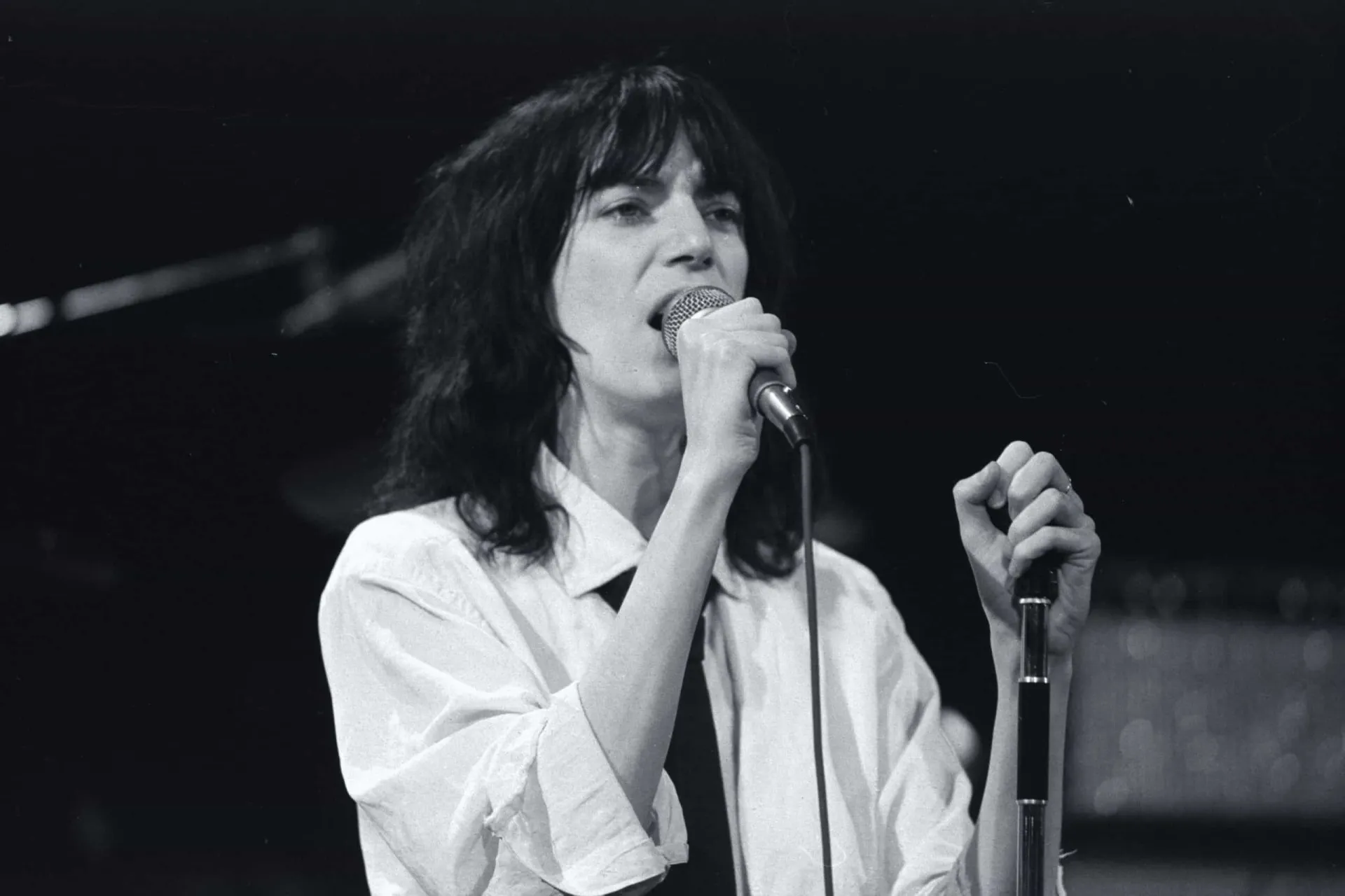A cantora e poetisa Patti Smith se apresentando no palco.