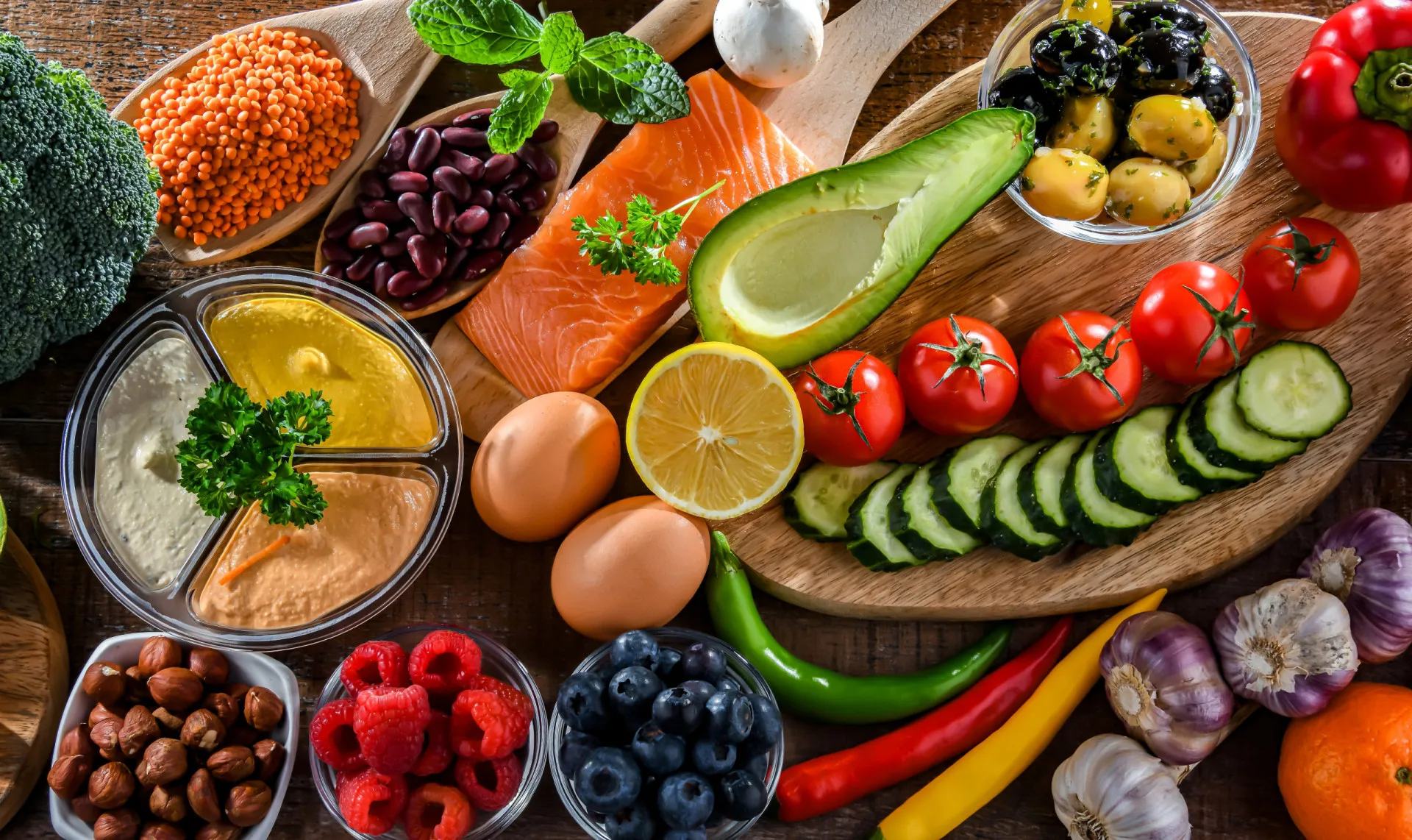 Uma mesa com azeite, peixes, nozes e vegetais, típica da dieta mediterrânea.