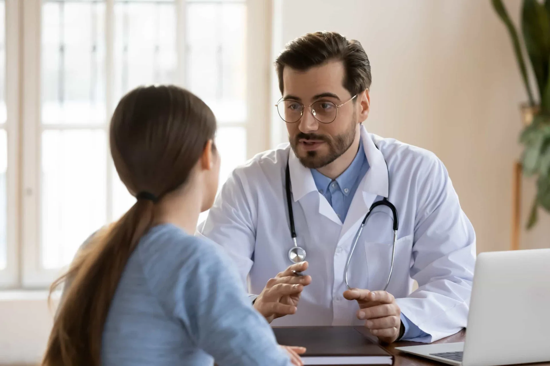 Paciente conversando com um médico em um consultório.