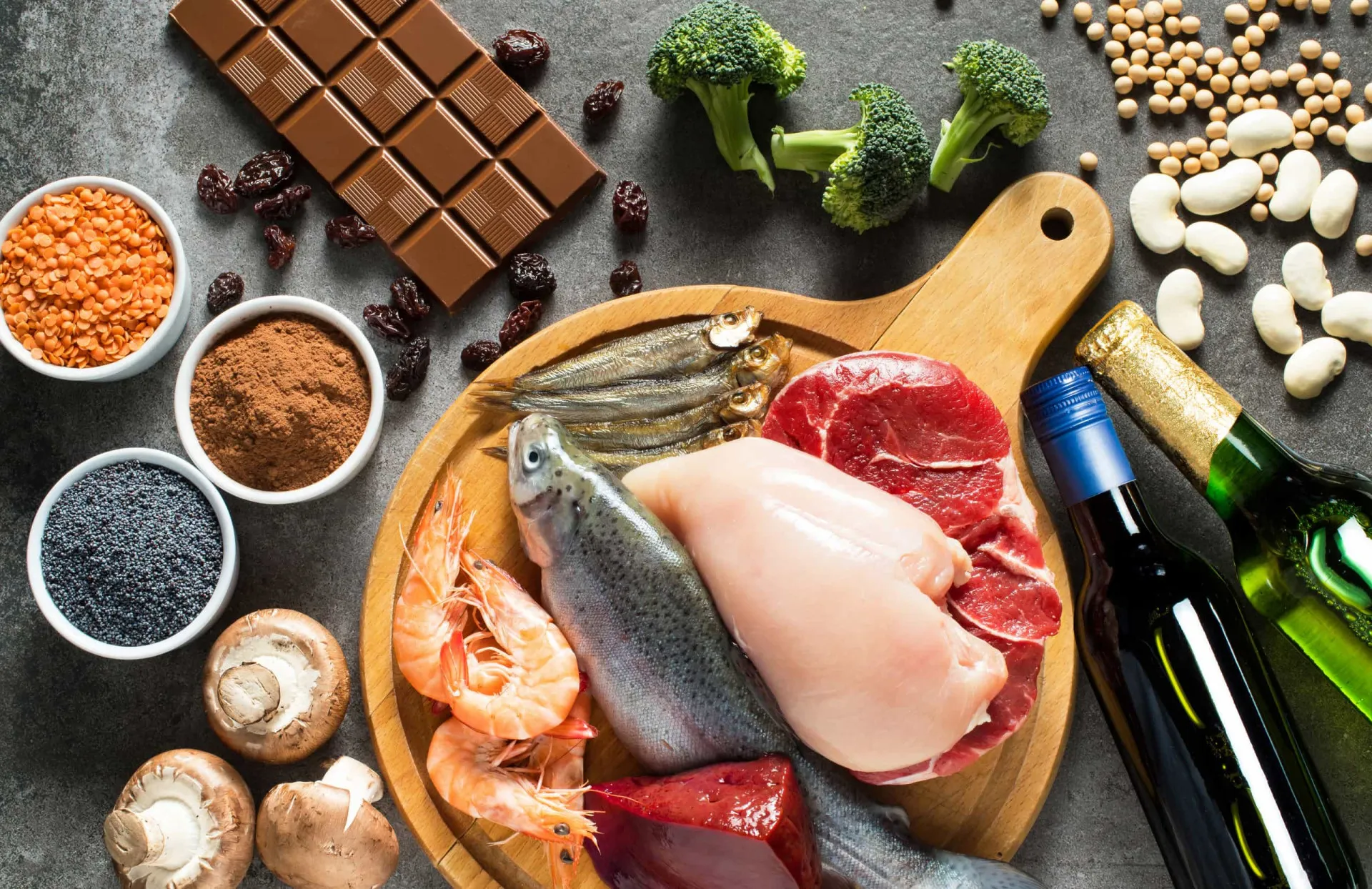 Prato com carne vermelha, frutos do mar e um copo de cerveja, alimentos ricos em purinas.