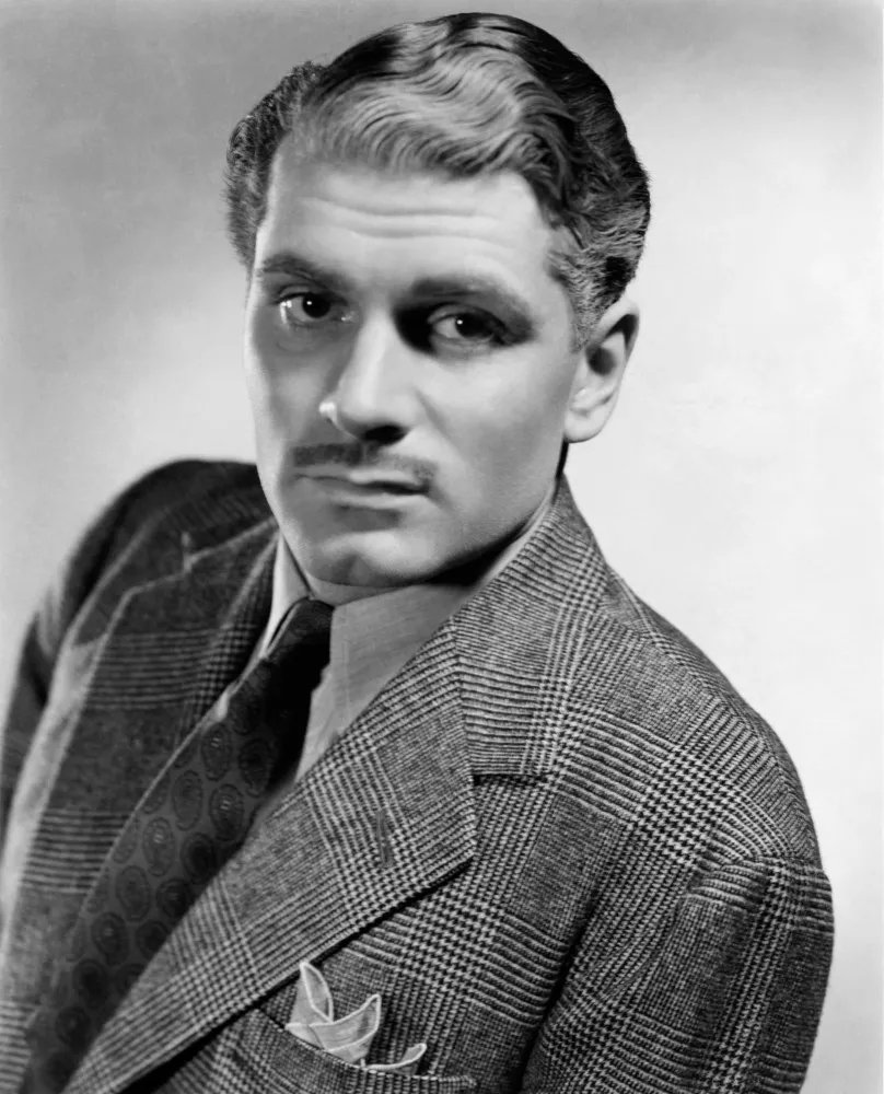 O ator britânico Laurence Olivier com um olhar intenso em uma cena de filme.
