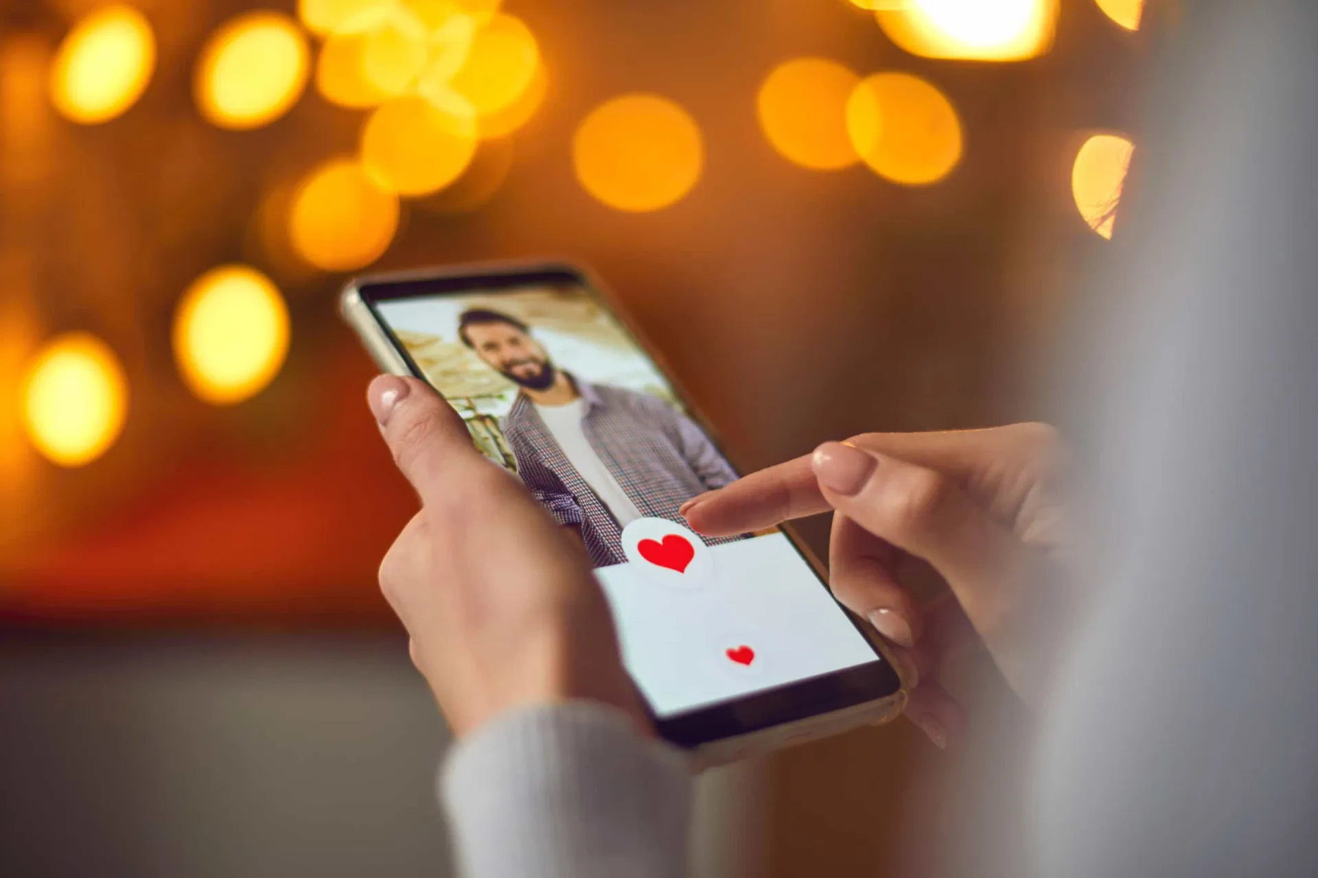 Celular com um aplicativo de namoro aberto na tela.