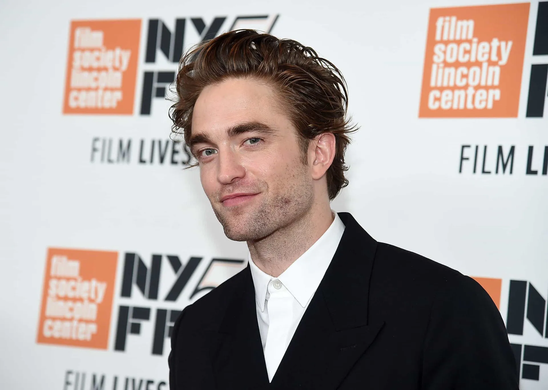 O ator Robert Pattinson em um evento, com o cabelo impecável.