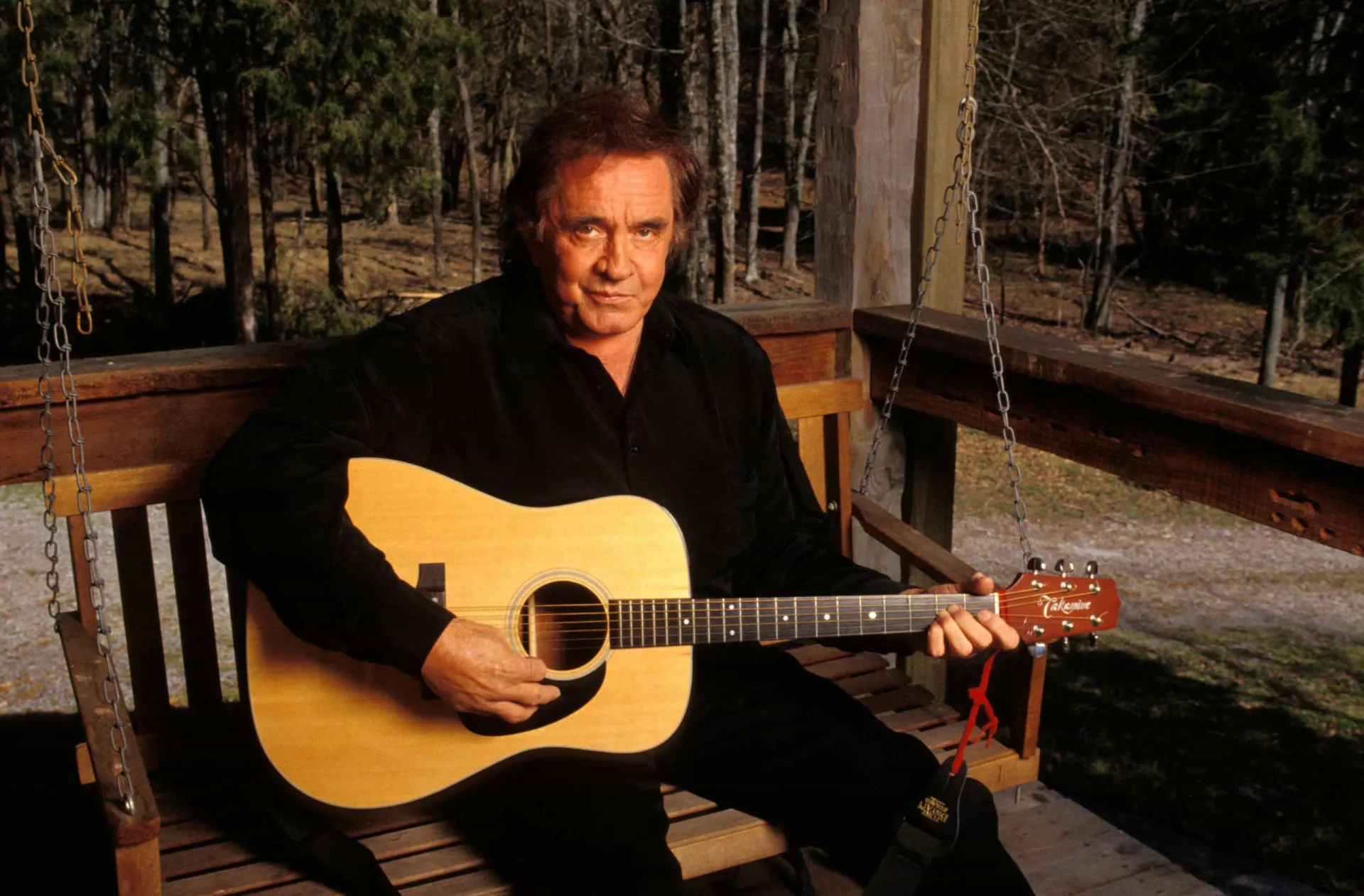 Johnny Cash com seu violão, em uma de suas imagens icônicas como o 'Homem de Preto'.