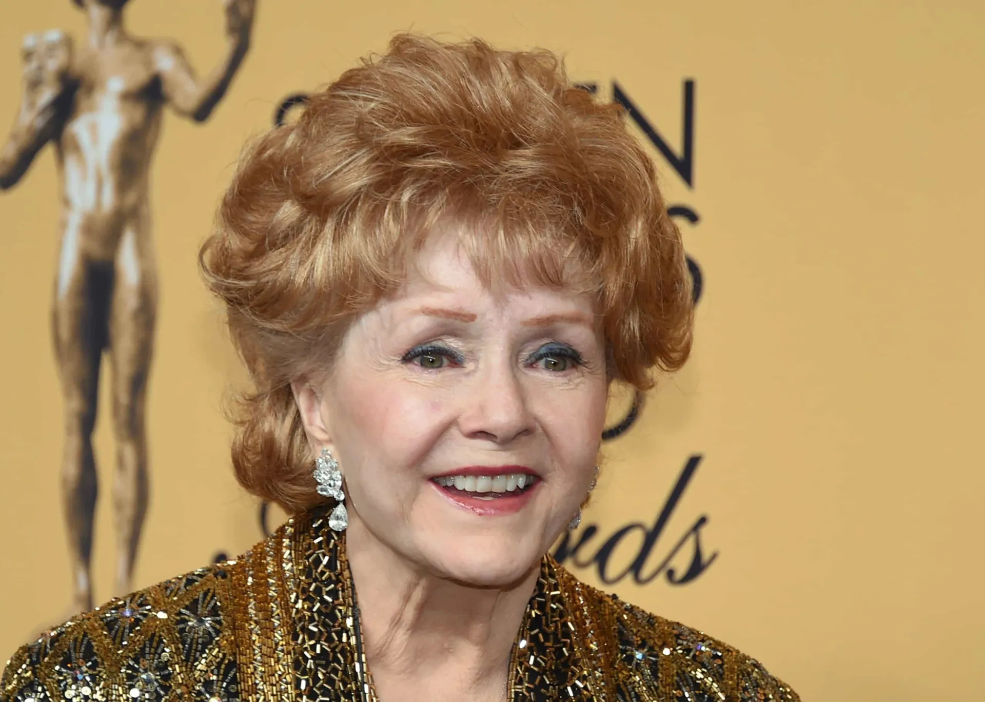 Debbie Reynolds sorrindo, uma imagem que representa sua carreira brilhante em Hollywood.