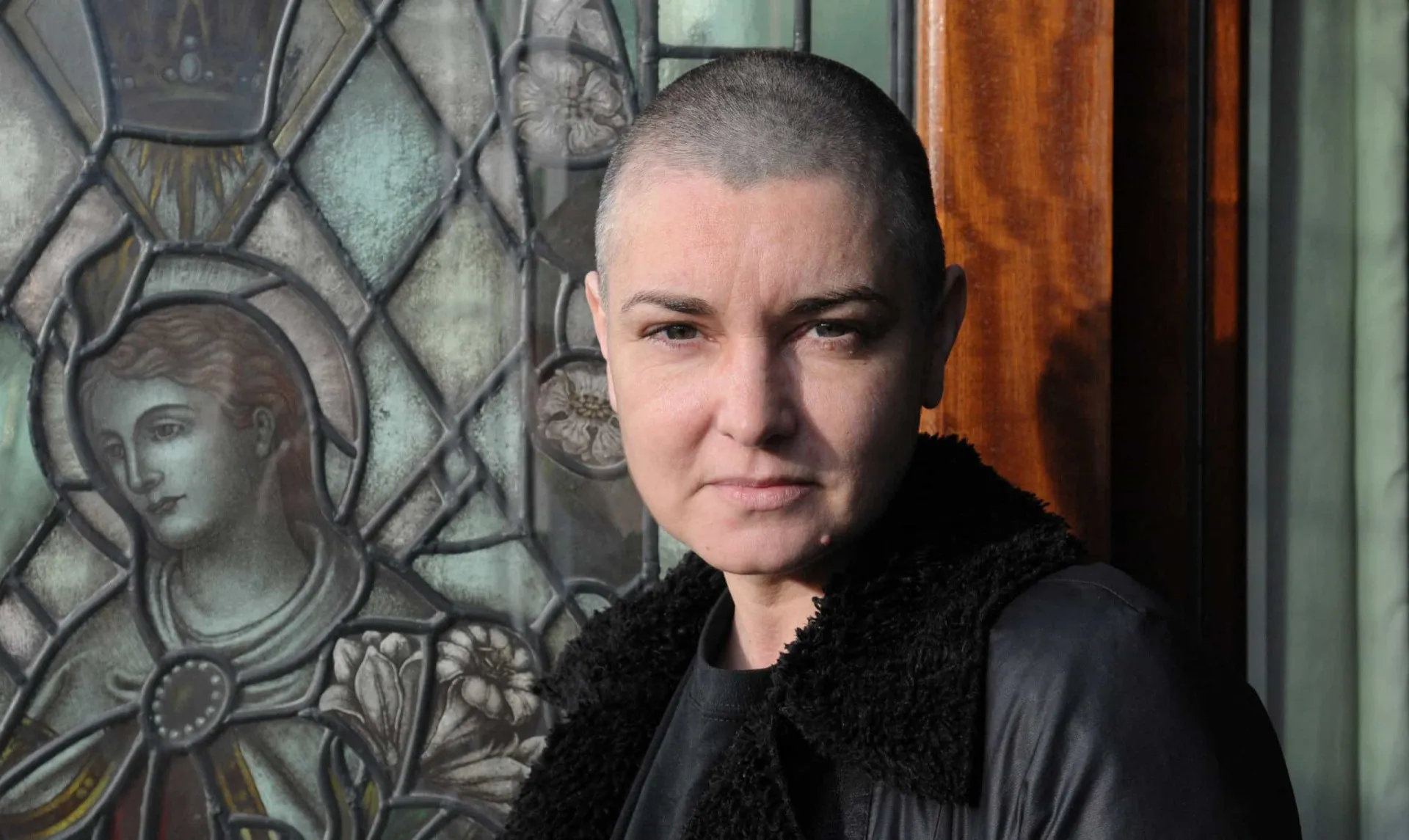 A cantora irlandesa Sinéad O'Connor em uma performance, com sua expressão intensa e marcante.