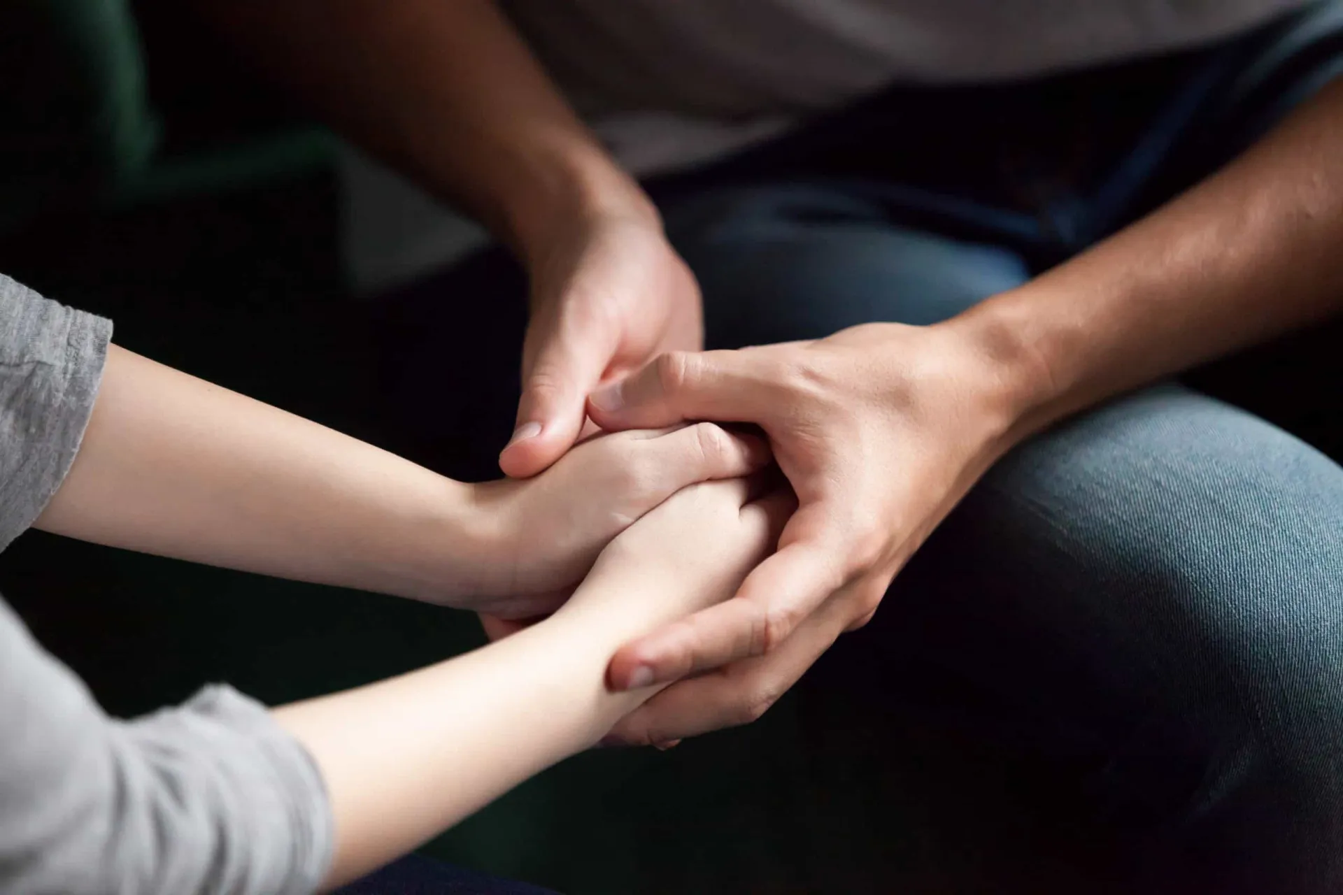 Mãos unidas em um gesto de apoio e conforto entre duas pessoas.