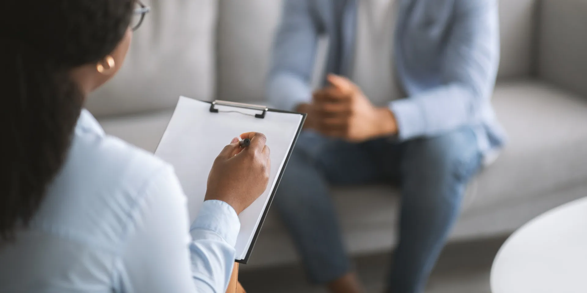 Terapeuta conversando com um paciente em uma sessão de psicoterapia, em um ambiente acolhedor.