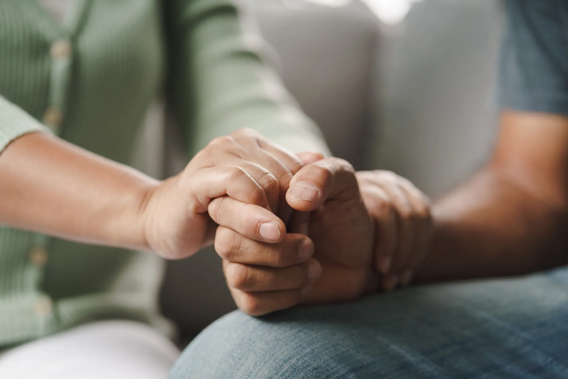 Mãos segurando outras, simbolizando apoio e cuidado contínuo após o tratamento.