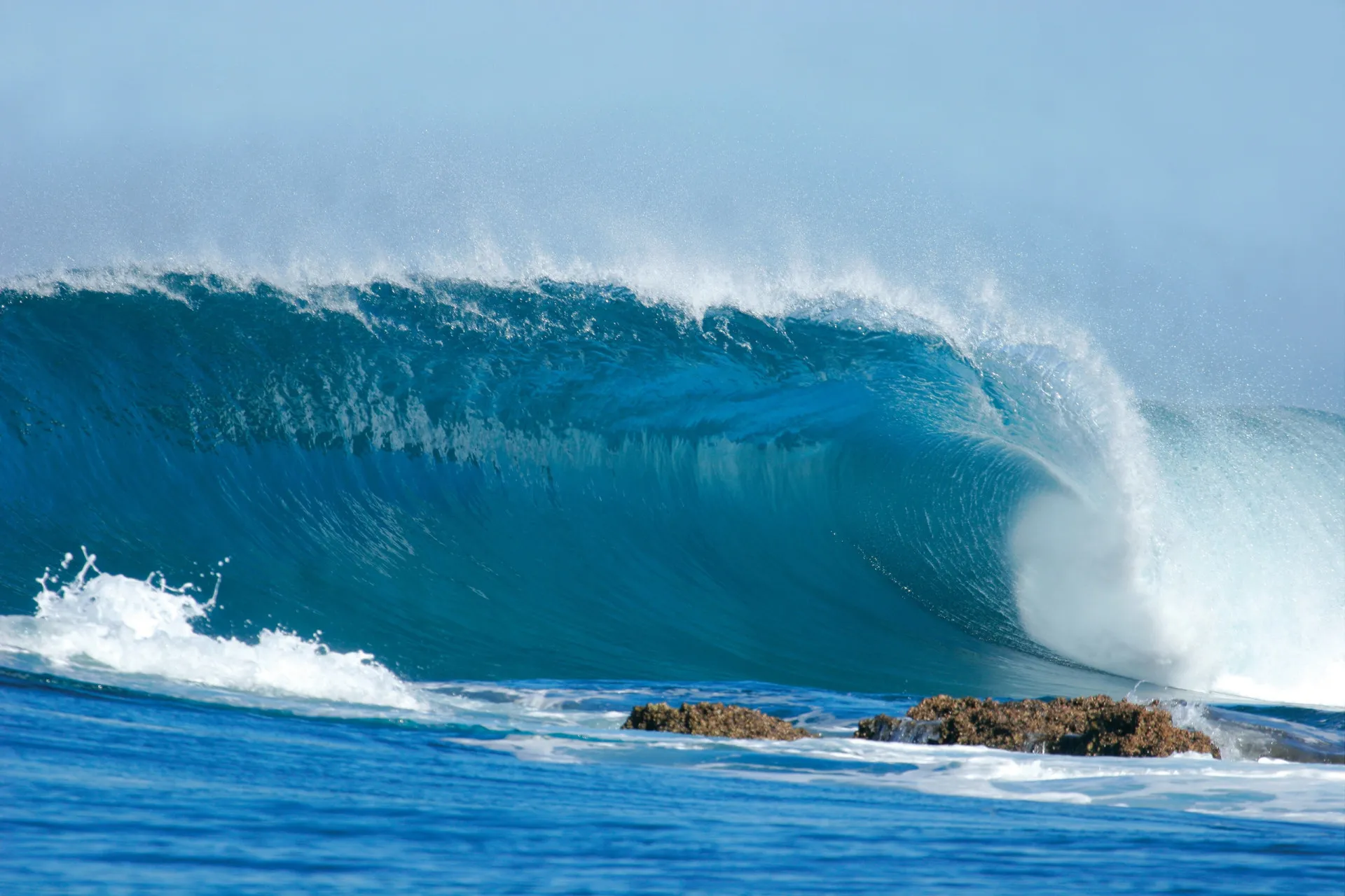 Ondas turbulentas e espumosas quebrando, sugerindo um som alto e poderoso.