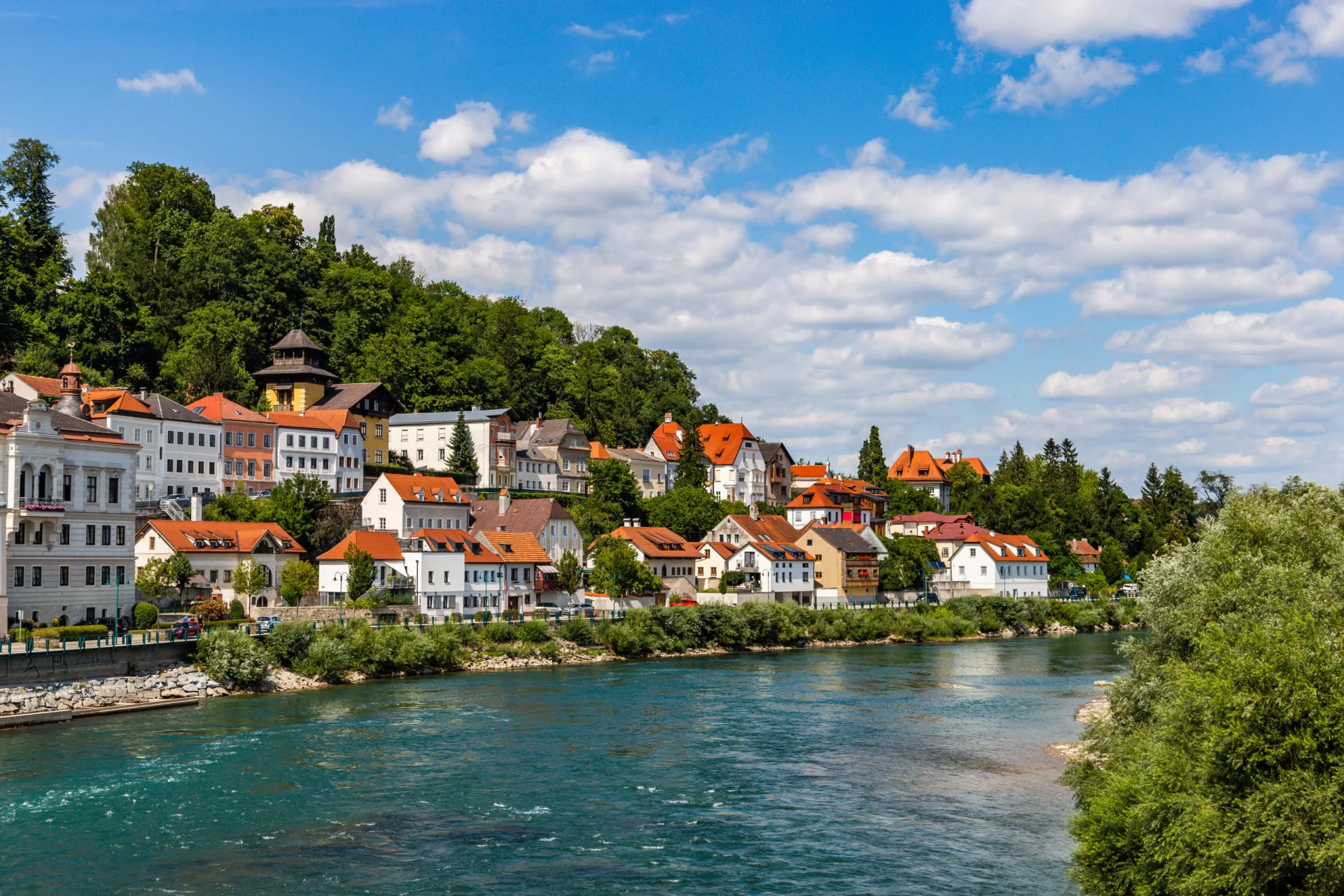 O rio Enns na Áustria, com águas claras e margens rochosas, cercado por florestas.