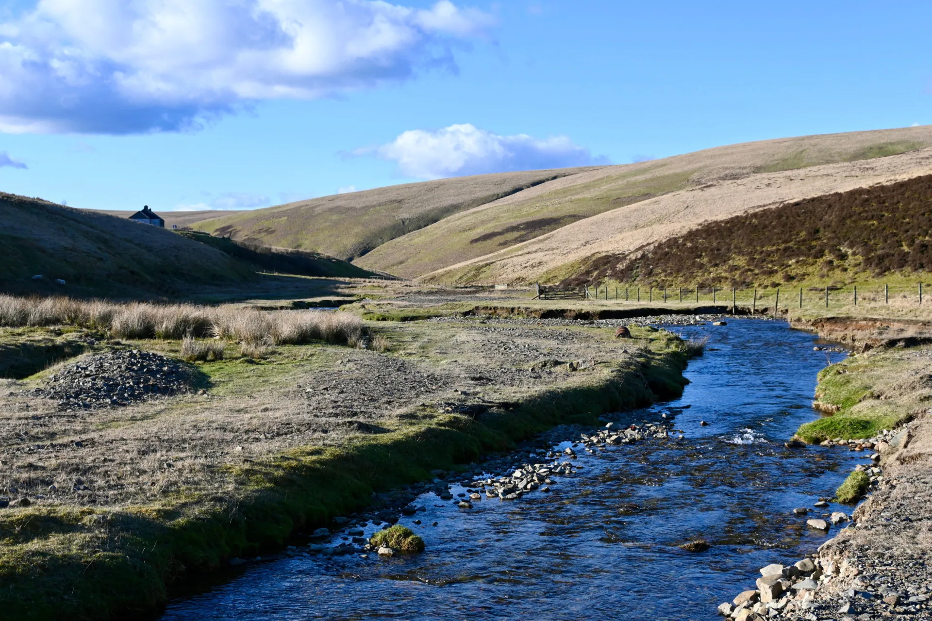 A vila de Wanlockhead na Escócia, com suas casas de pedra em um vale verde.