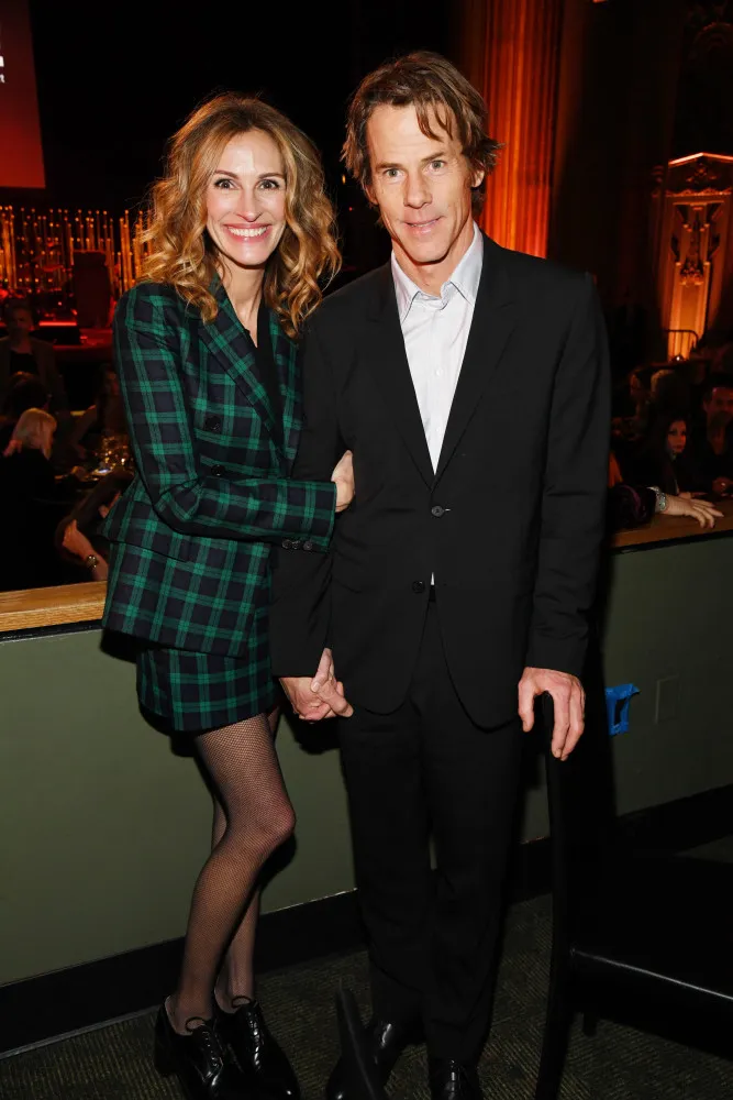 Julia Roberts e Danny Moder caminhando juntos, com um visual descontraído.