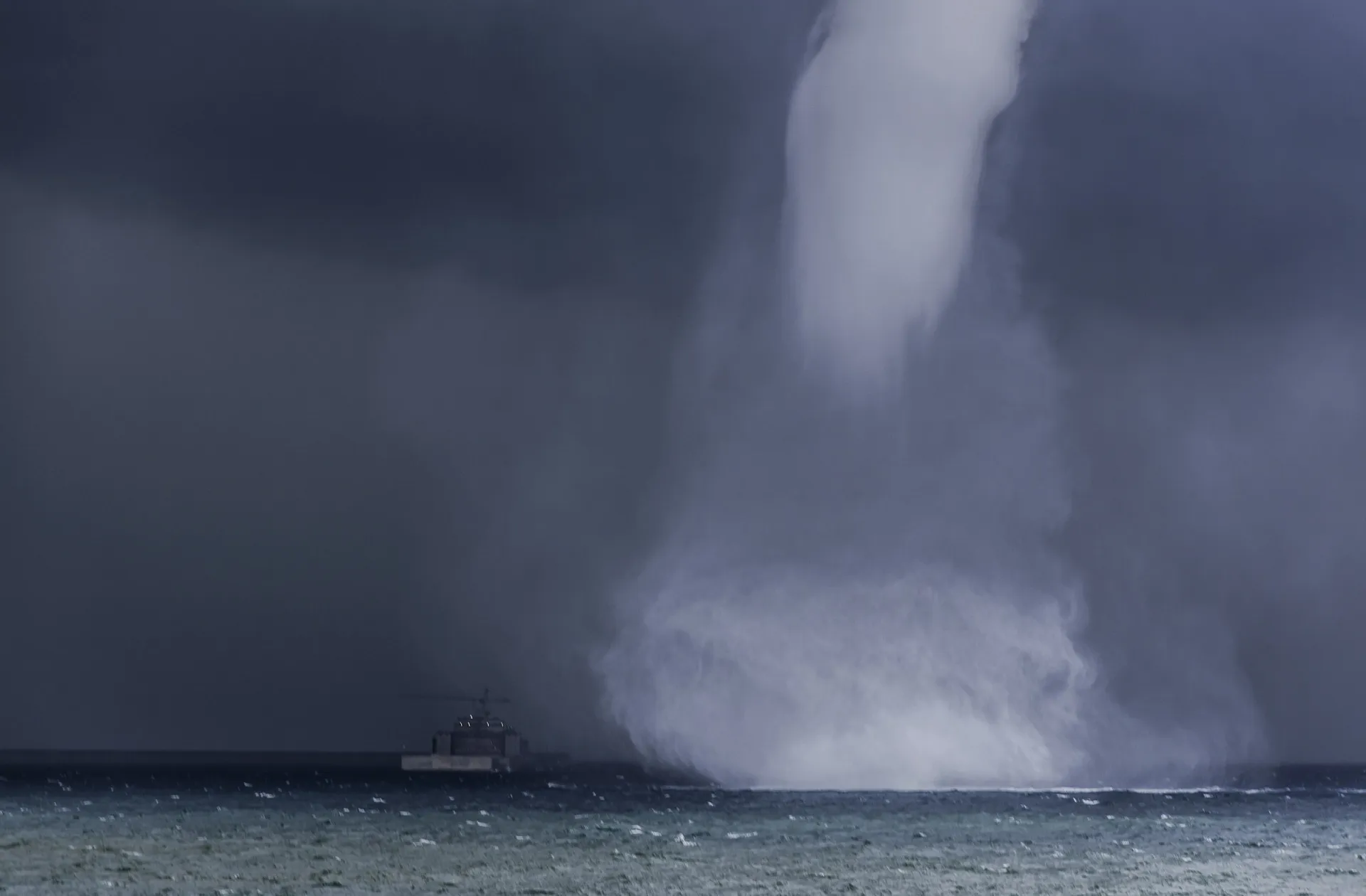 Uma poderosa corrente de ar descendente (downburst) atingindo a superfície da água, criando uma explosão de spray.