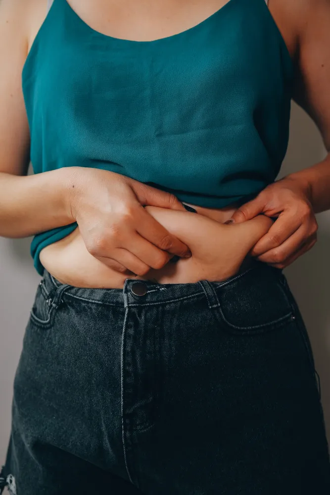 Gráfico estilizado mostrando o aumento percentual da gordura abdominal em mulheres na pós-menopausa.