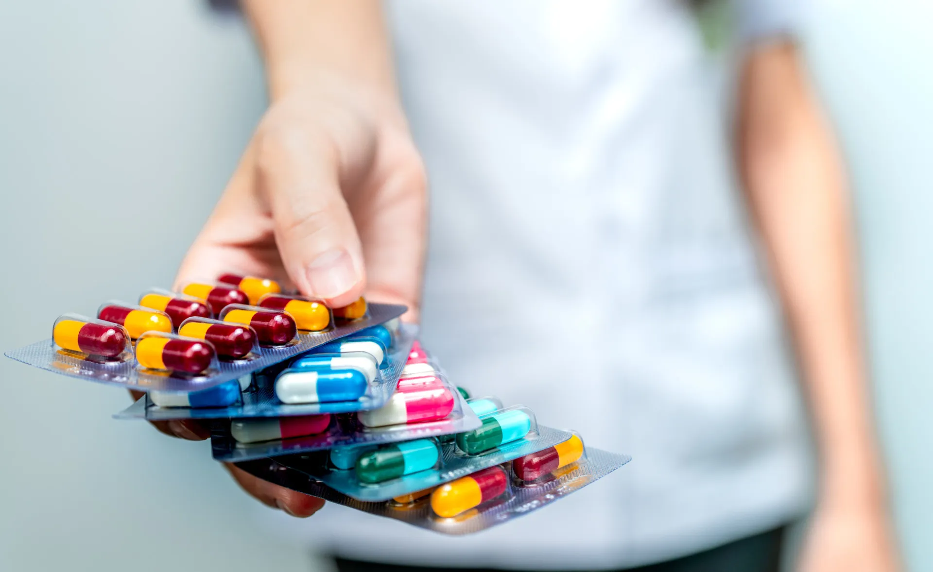 Vários comprimidos e cápsulas de medicamentos psiquiátricos espalhados.