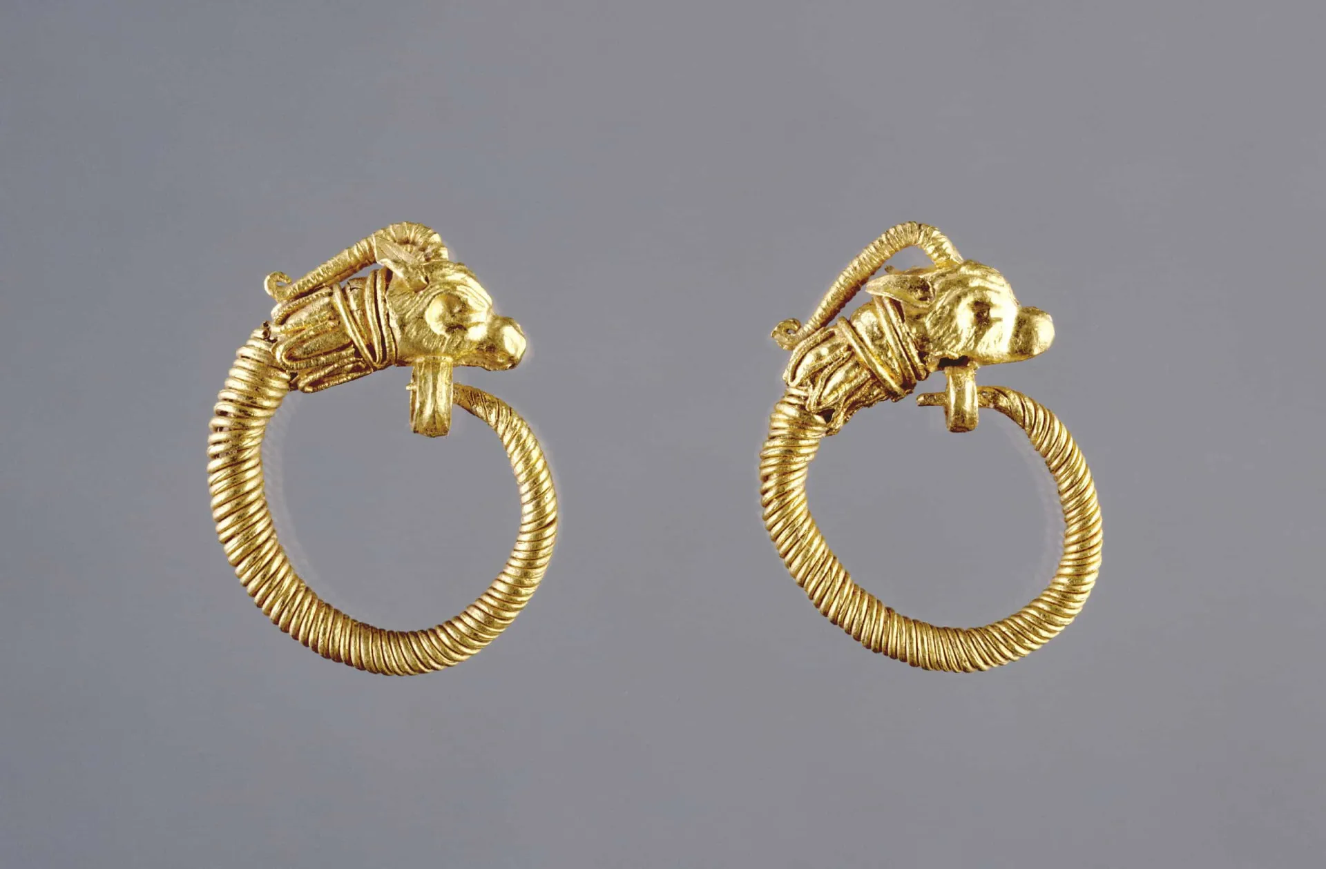 Par de brincos de argola de ouro da Grécia Antiga com detalhes gravados.
