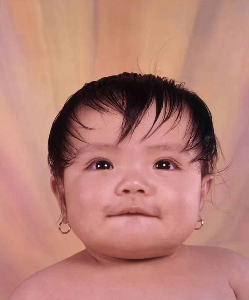 Kylie Jenner segurando sua filha Stormi, que usa pequenos brincos, gerando um debate online.