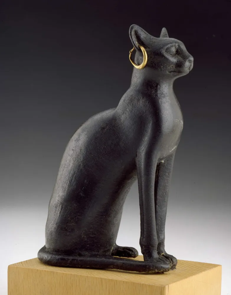 Estátua de bronze de um gato do Antigo Egito usando um brinco de argola dourado.