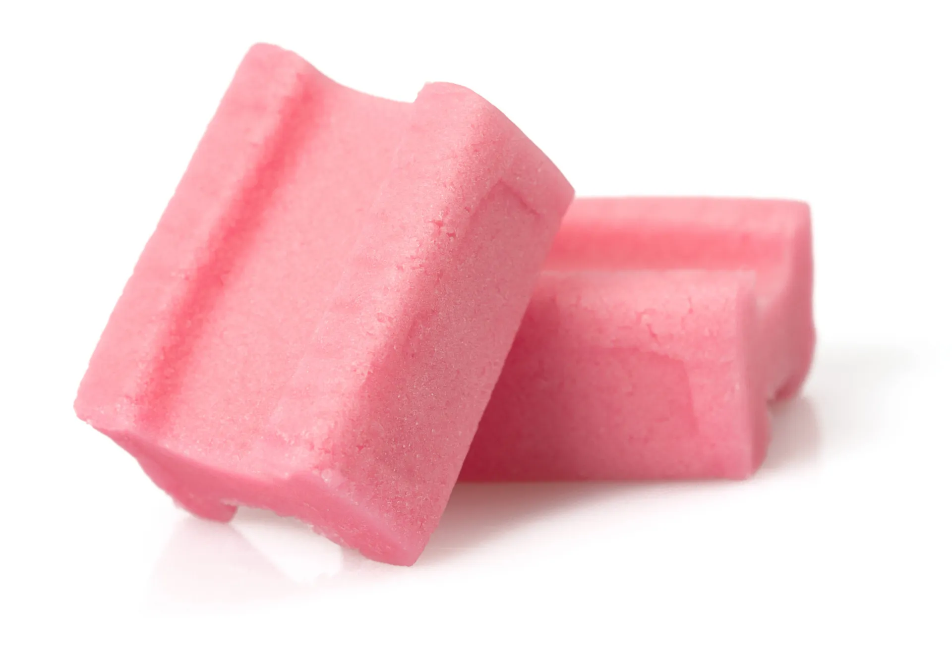 Uma pessoa soprando uma grande bola de chiclete rosa.