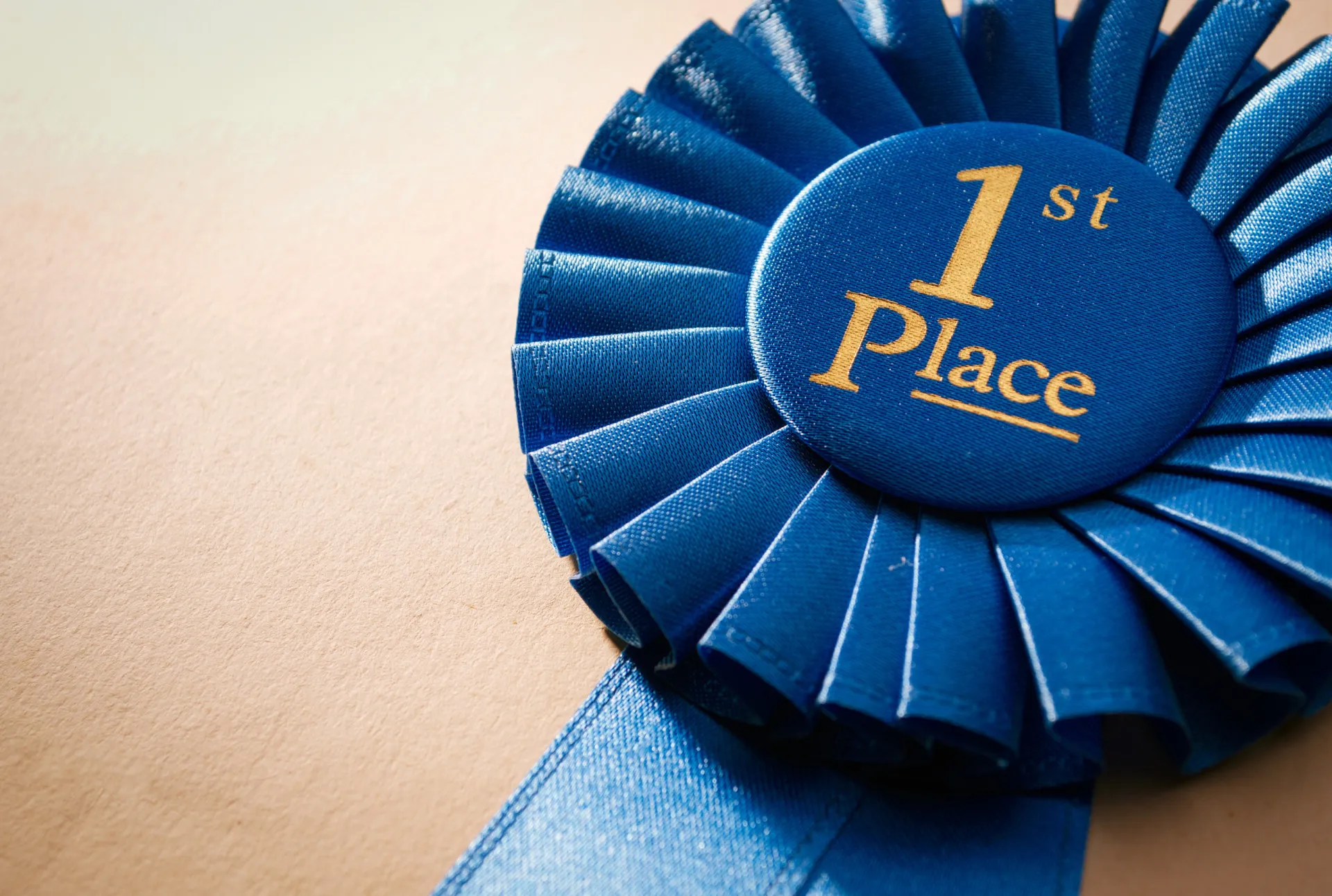 Uma fita azul de primeiro lugar com uma medalha dourada no centro.