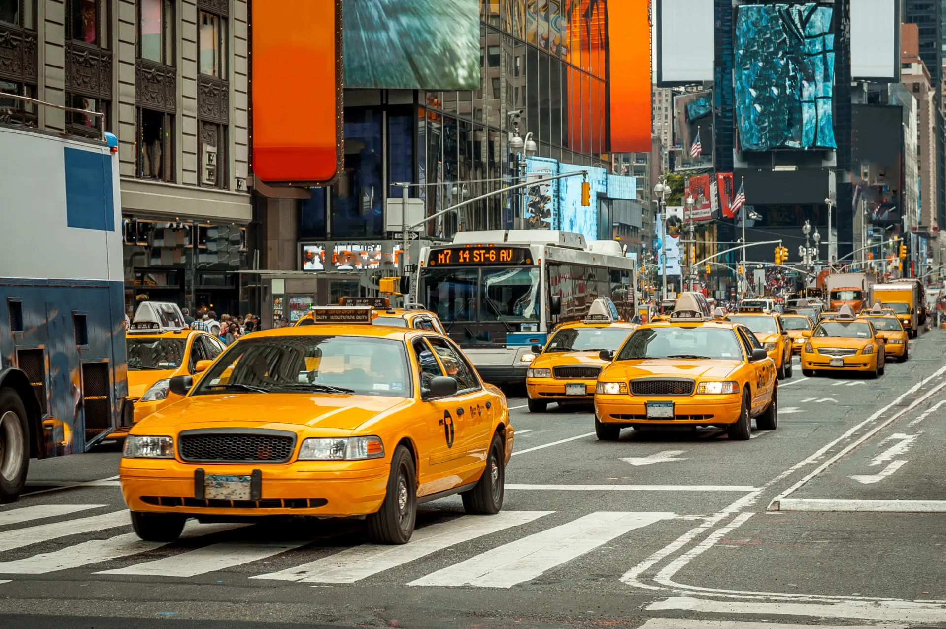 Uma frota de táxis amarelos icônicos em uma rua movimentada de Nova York.