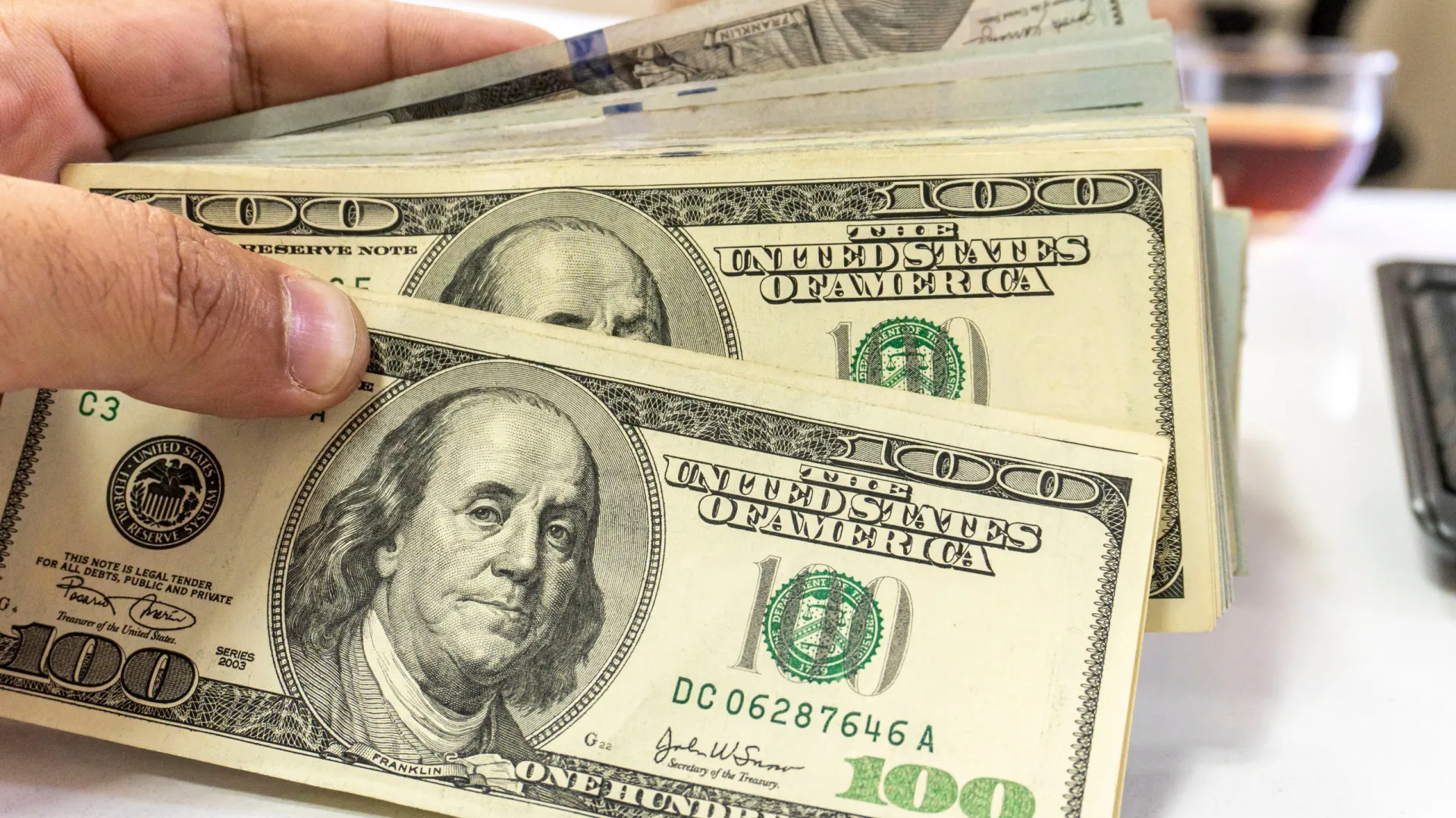 Uma pilha de notas de dólar americano, destacando sua cor verde característica.