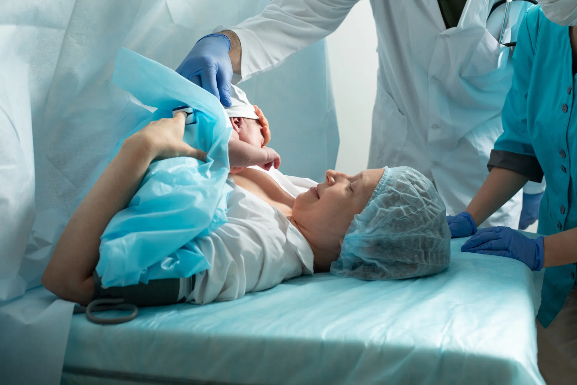 Equipe médica em uma sala de cirurgia preparando para uma cesariana.