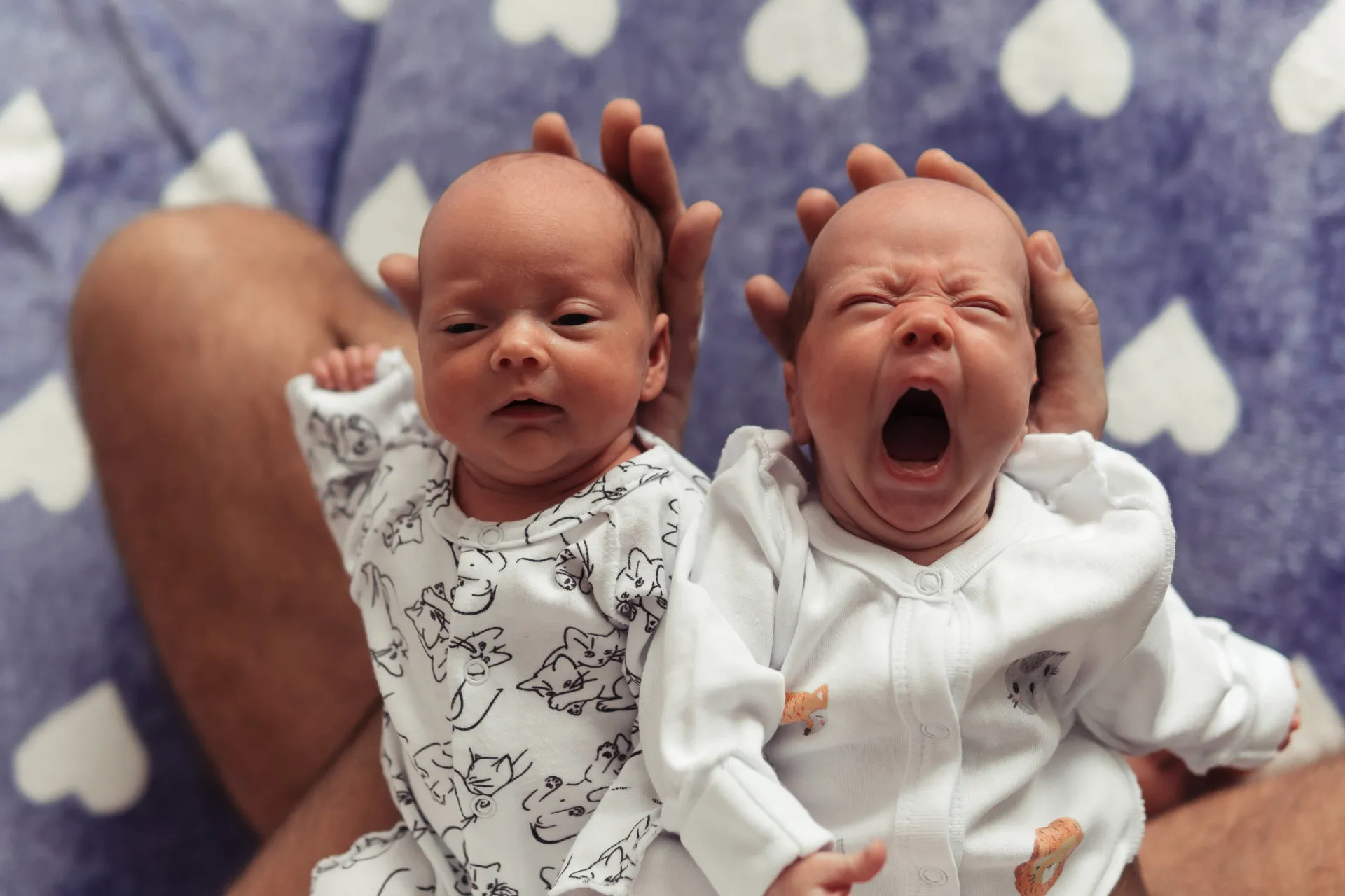 Dois bebês recém-nascidos juntos, um ligeiramente menor que o outro.