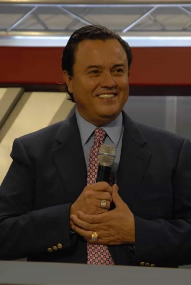 José Luis de Jesús Miranda em um palanque, gesticulando para uma multidão durante um evento de sua igreja.