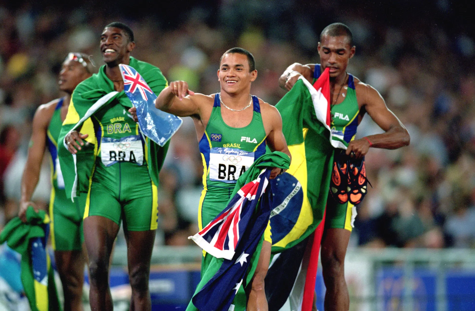 Atletas do revezamento 4x100 masculino do Brasil comemoram a medalha de prata em Sydney.