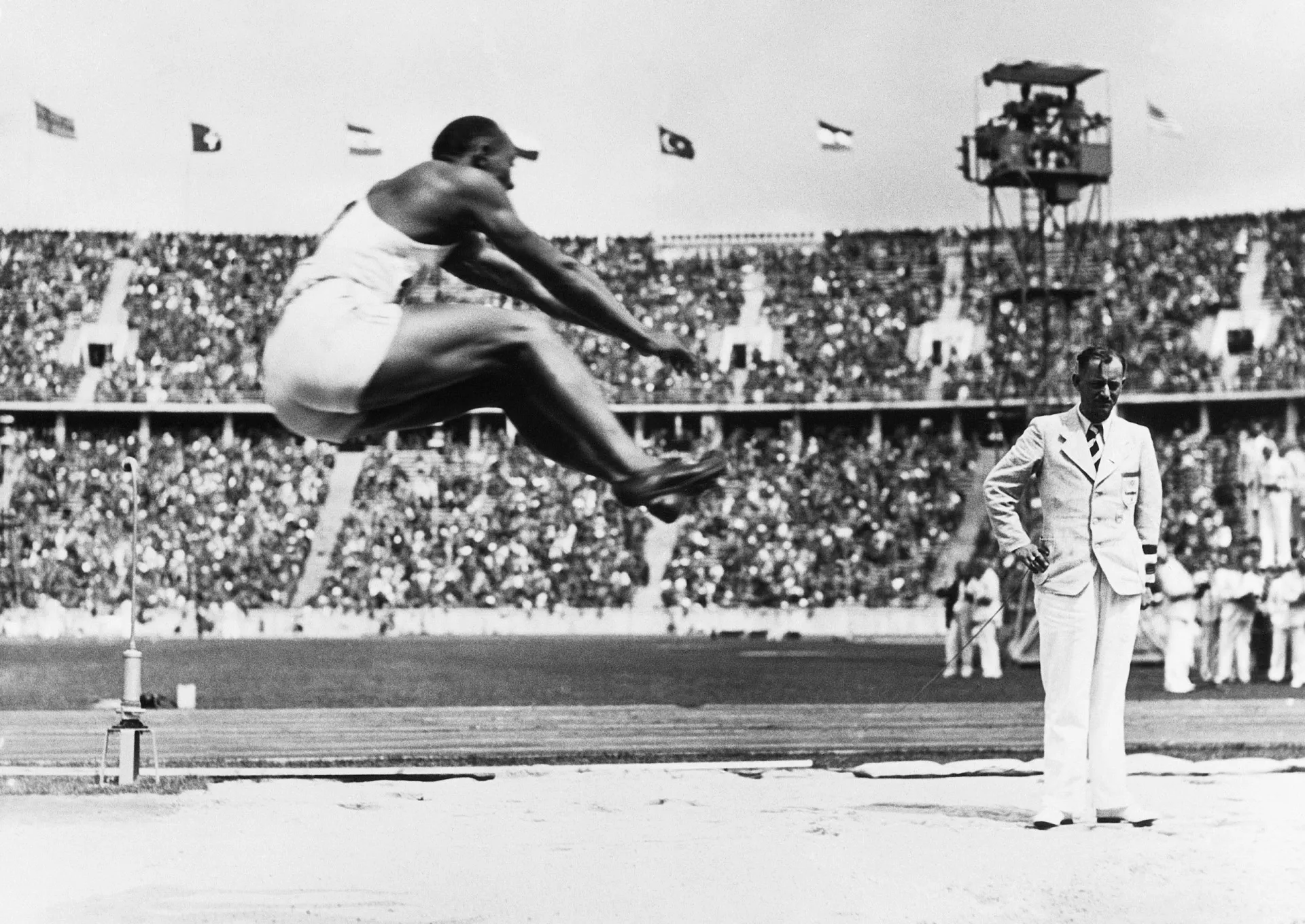 O atleta americano Jesse Owens em ação no salto em distância durante os Jogos de Berlim.
