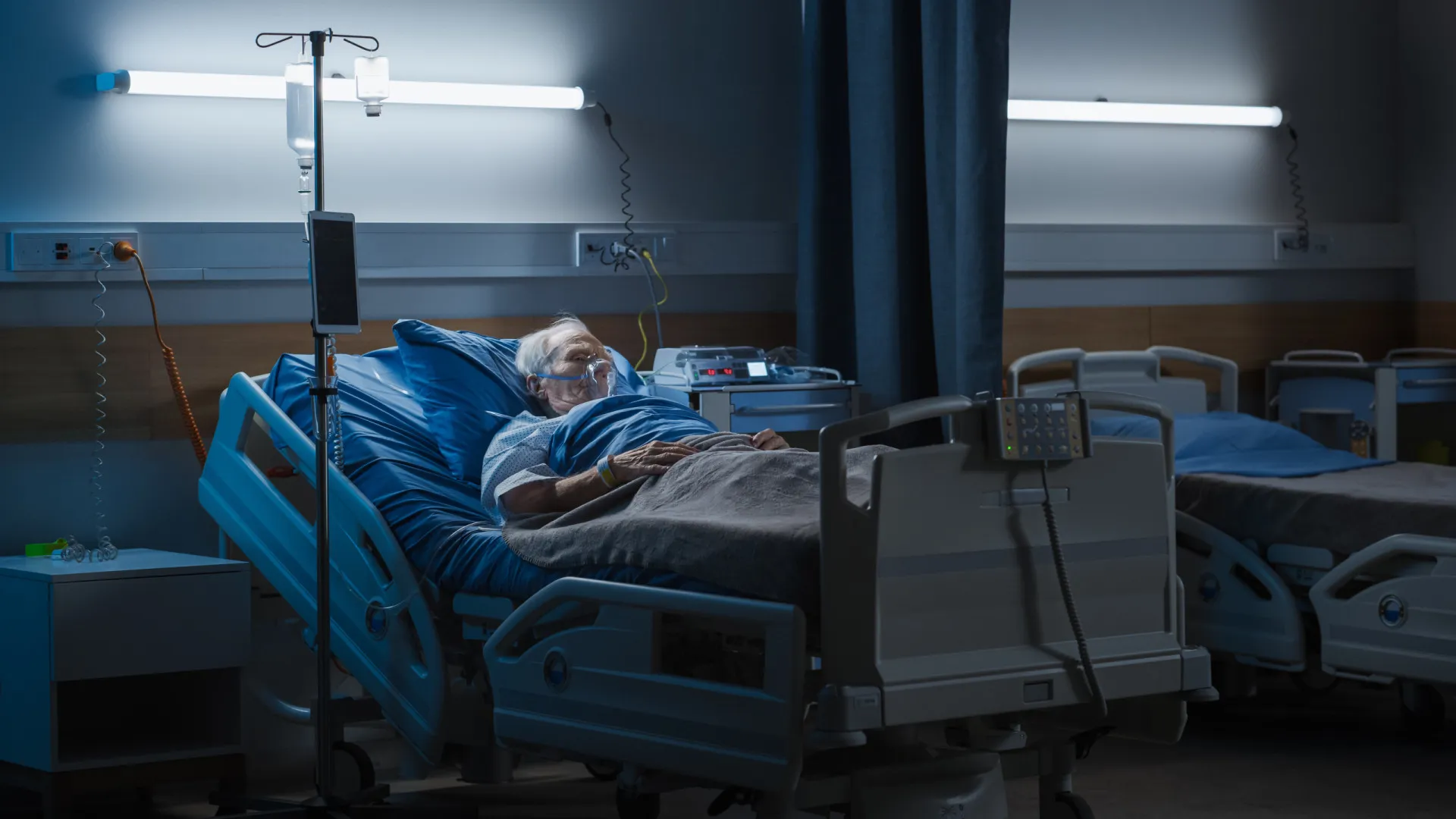 Pessoa idosa sozinha em um quarto de hospital, olhando para a porta com esperança.