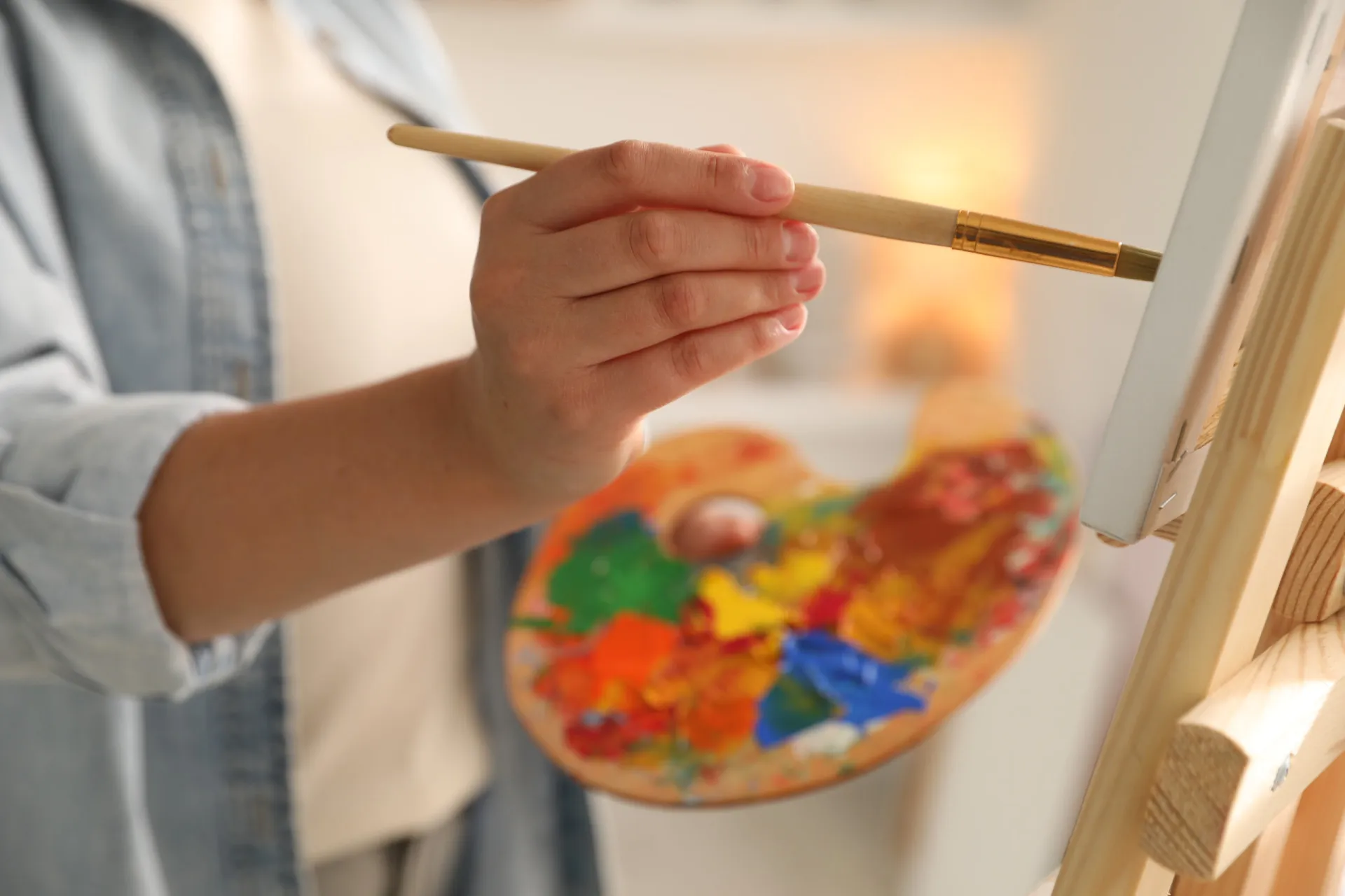 Pessoa pintando um quadro com entusiasmo, imersa em sua paixão pela arte.