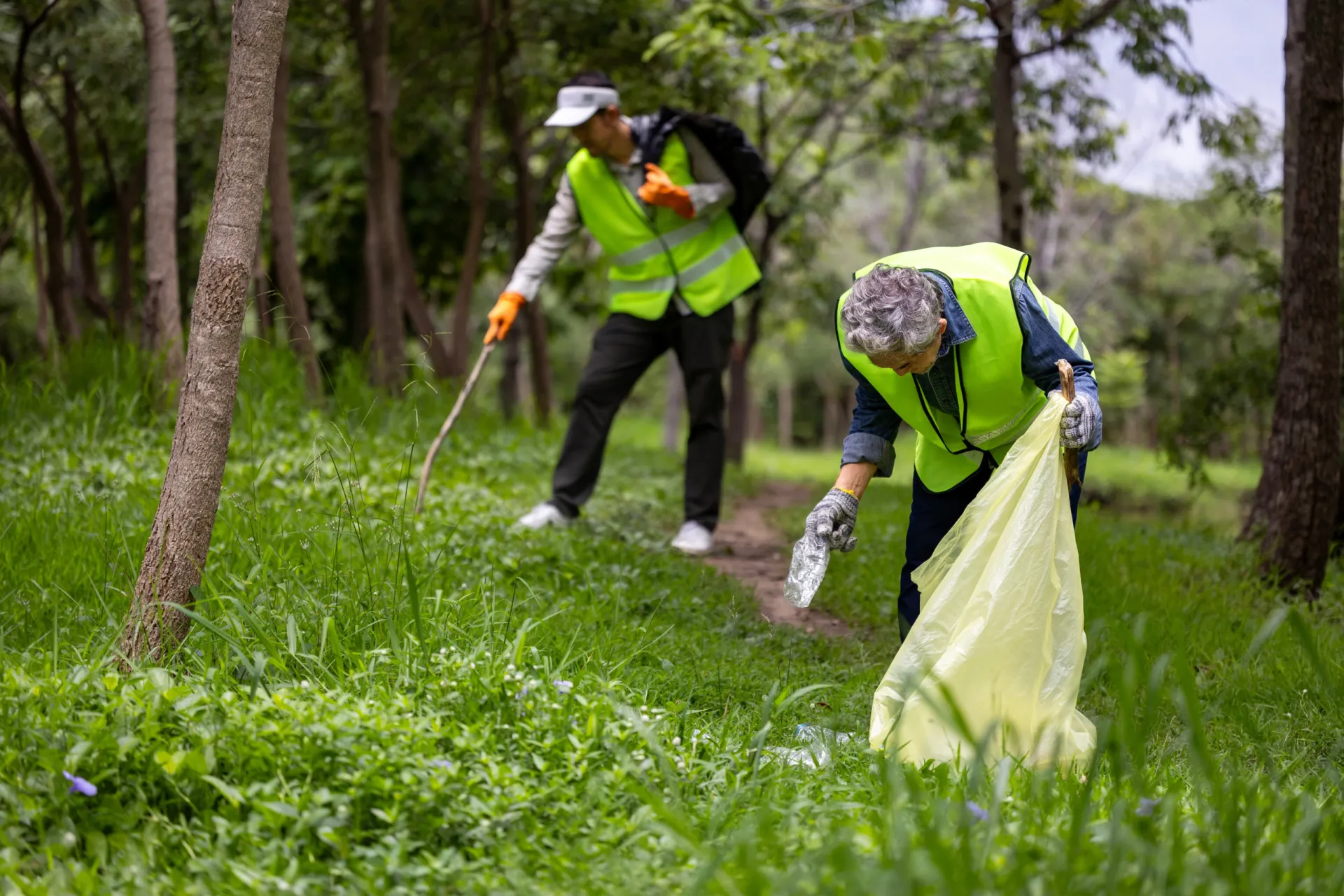 Grupo de voluntários trabalhando juntos para limpar um parque, demonstrando espírito comunitário.