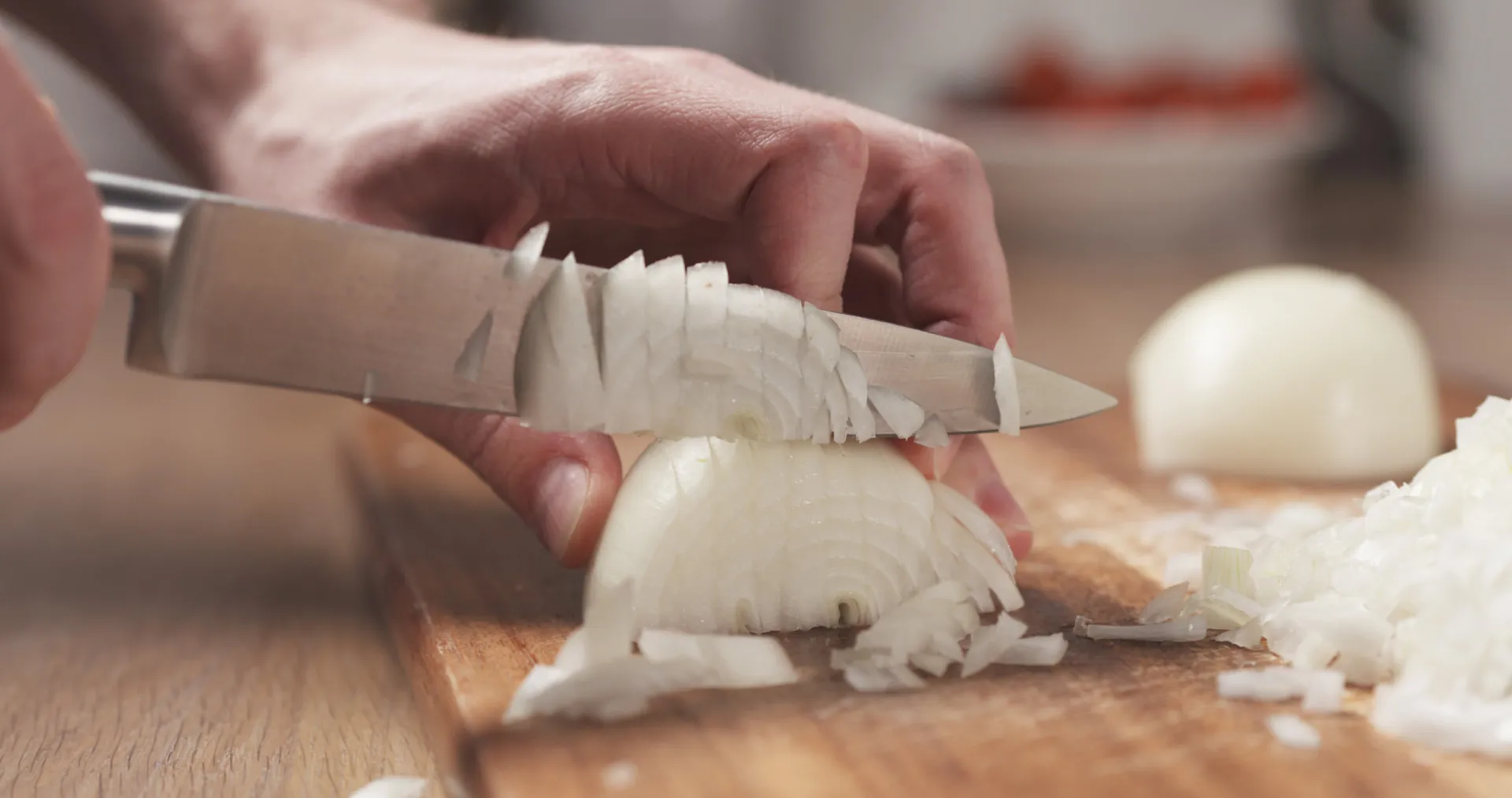 Cebolas sendo cortadas em fatias finas por um chef.